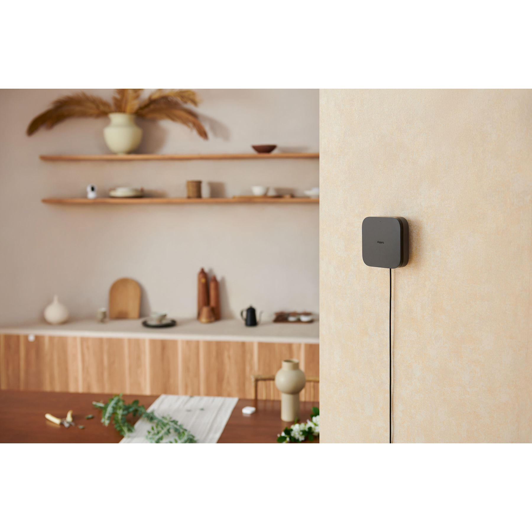 Ein Smart-Home-Hub an einer Wand, mit einer verschwommenen Innenszene im Hintergrund mit Regalen und einem Tisch.