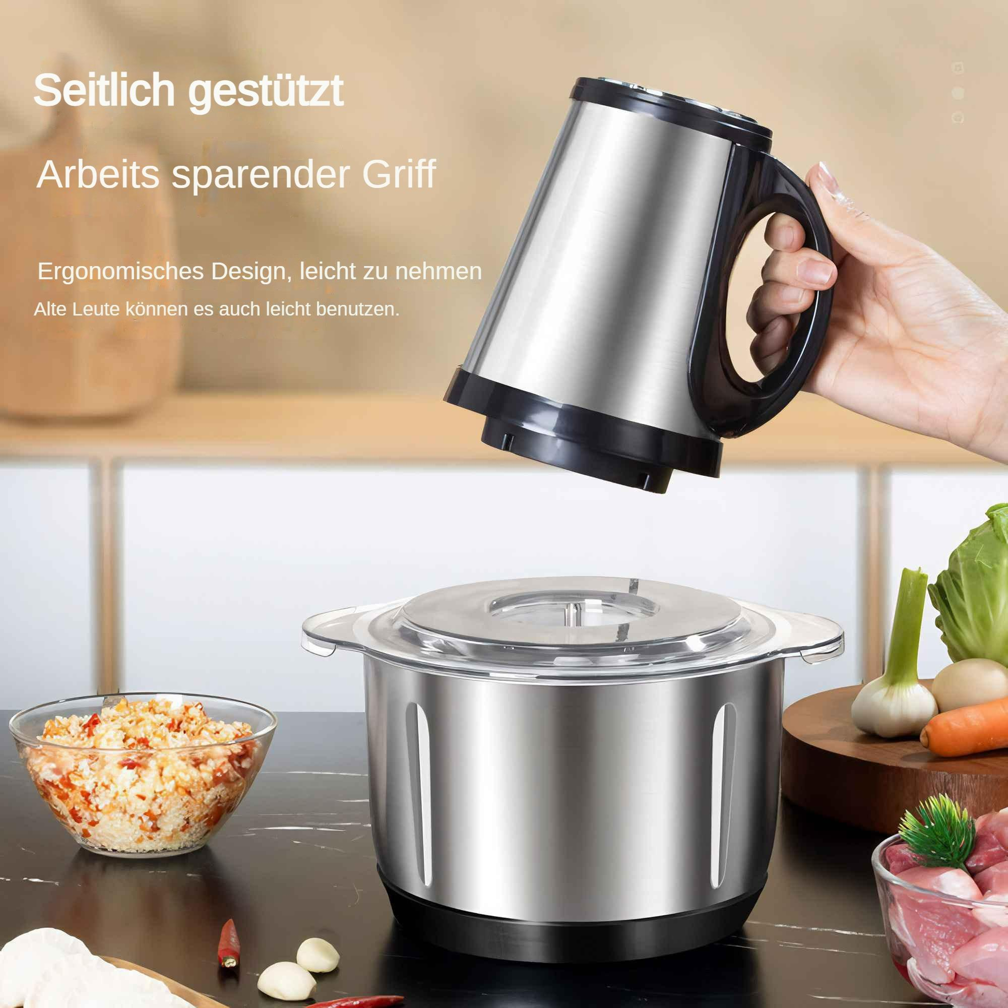 Eine Hand hält einen Metall-Lebensmittelverarbeitungsdeckel. Auf dem Tisch stehen eine Schüssel mit gehackten Lebensmitteln sowie Gemüse und Fleisch.