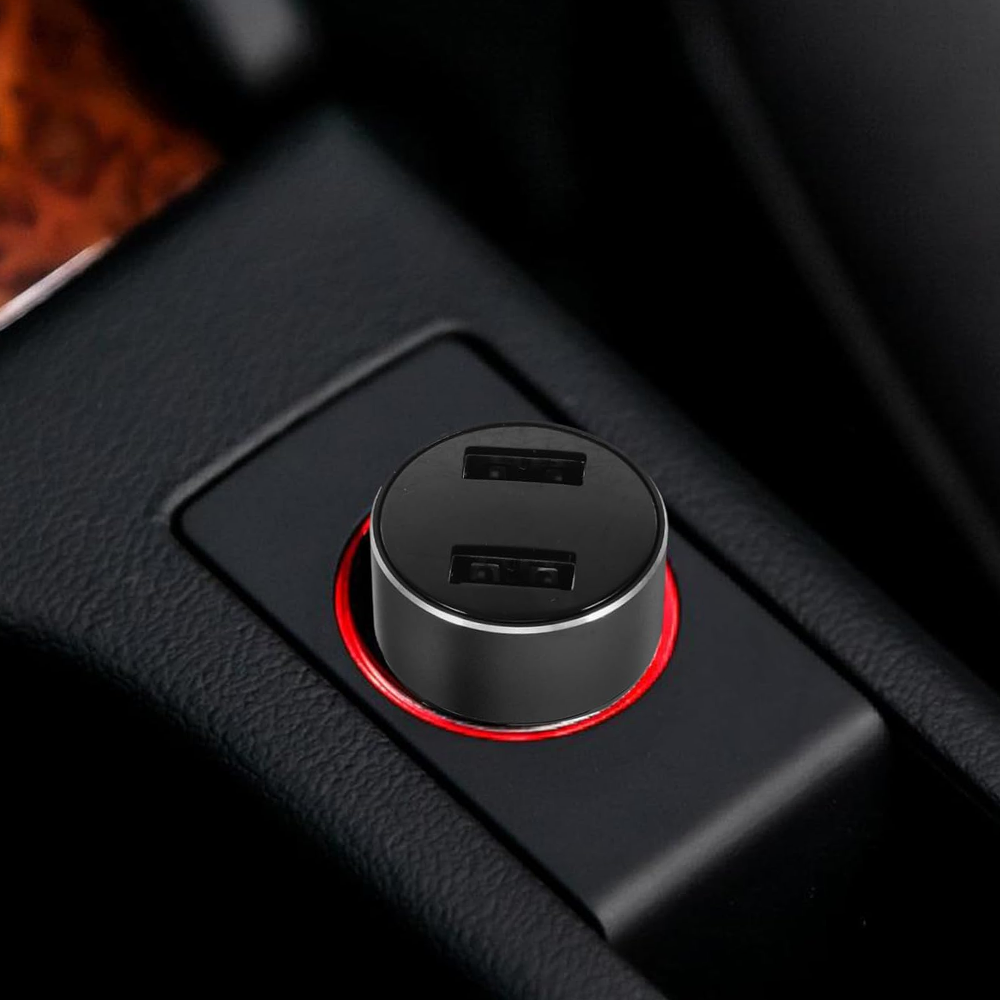 Ein schwarzes USB-Autoladegerät mit zwei Anschlüssen ist in die Konsole eines Autos eingesetzt. Ein rotes Licht umgibt das Ladegerät.