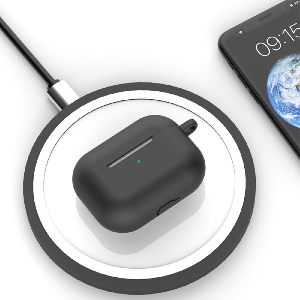 Funda negra de AirPods en un cargador inalámbrico, junto a un teléfono que muestra la hora. Cable conectado al cargador. Fondo blanco.