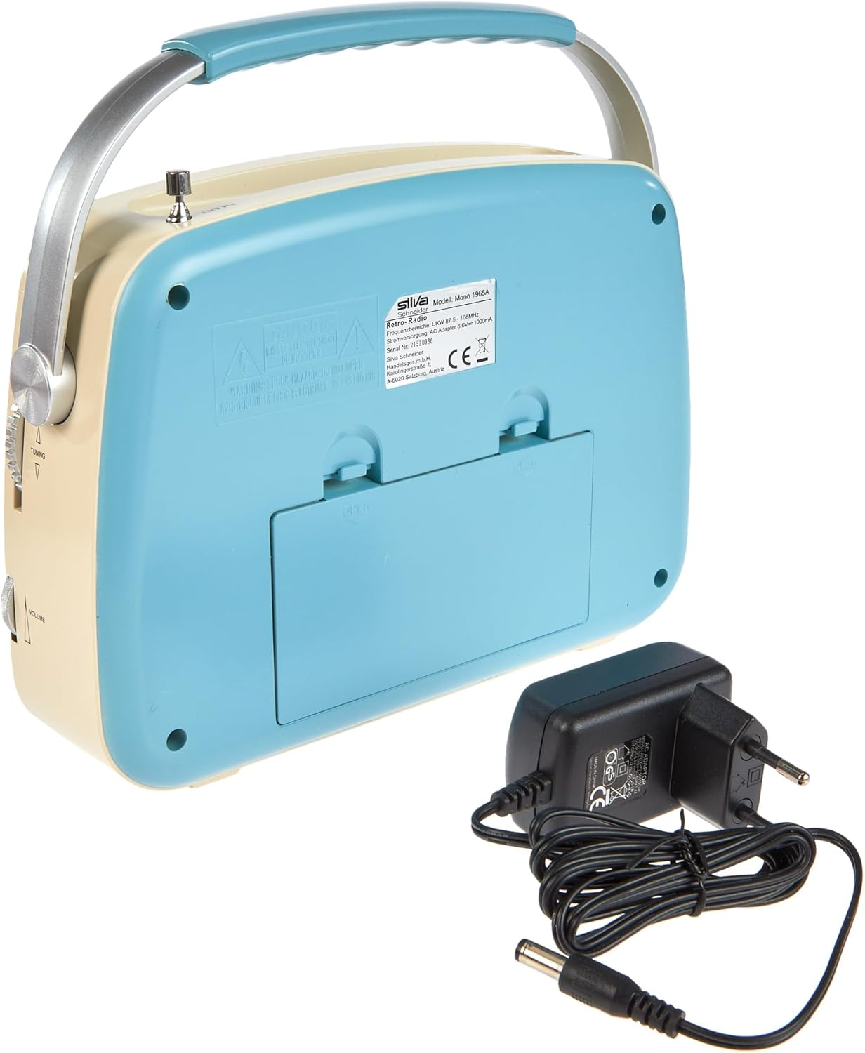 Ein Retro-Radio mit Griff und Netzteil. Das Radio ist cremefarben und blau. Der Adapter ist schwarz.