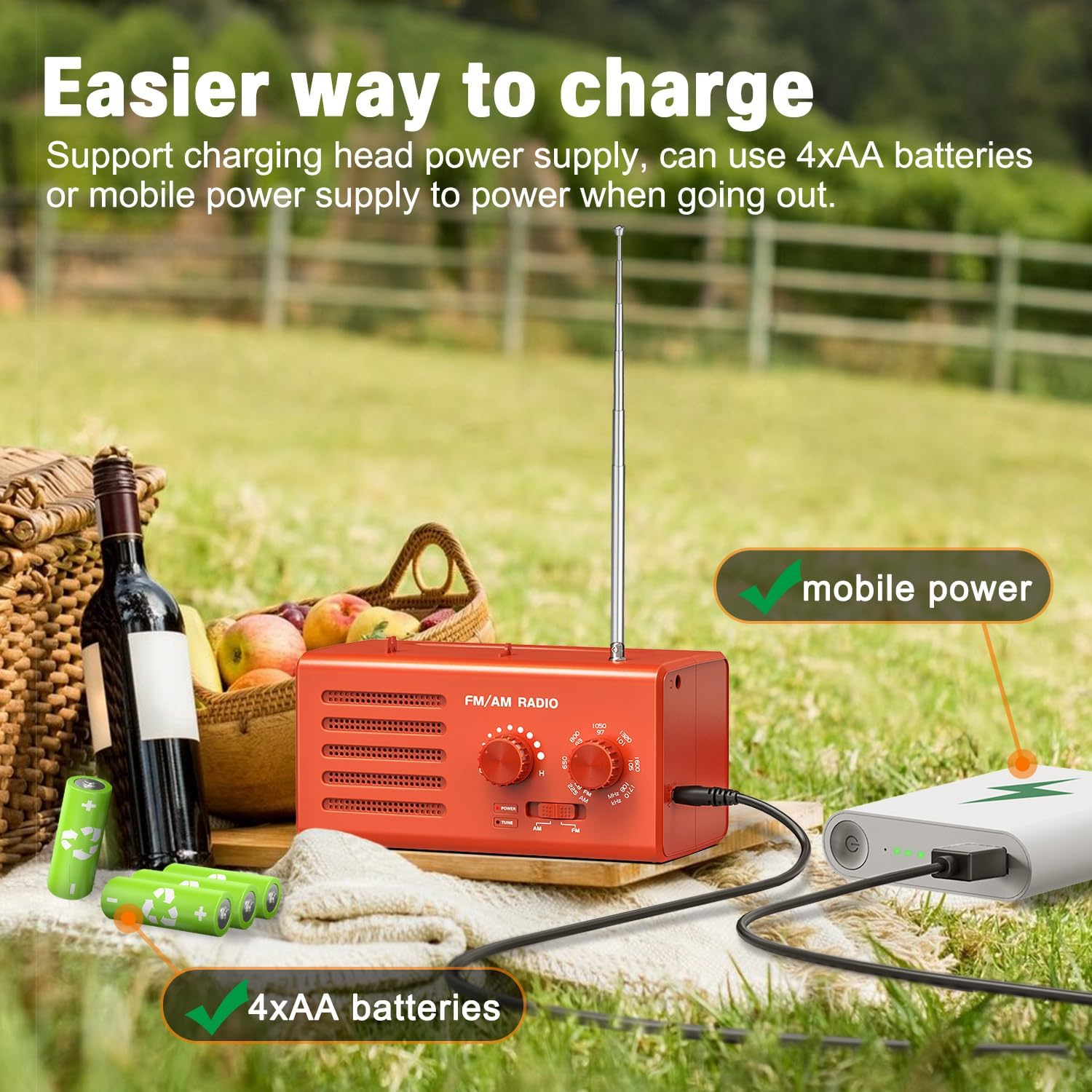 Ein orangefarbenes Radio, das an eine Powerbank angeschlossen ist. Außerdem gibt es 4xAA-Batterien und einen Picknickkorb mit Früchten.
