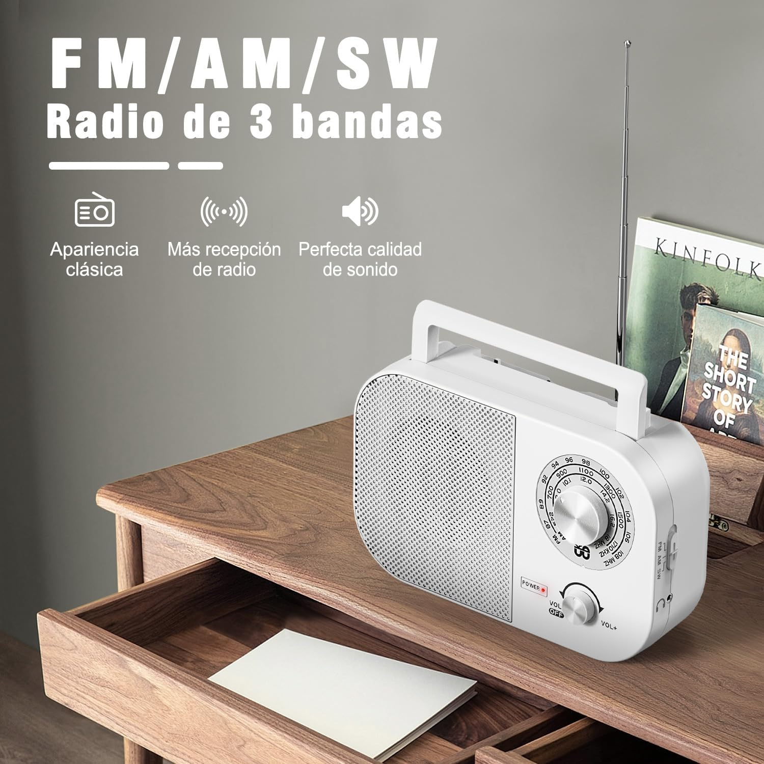 Weißes Retro-Radio mit Griff auf einem Holztisch. Ein Buch und eine Schublade mit Papier sind ebenfalls auf dem Tisch.
