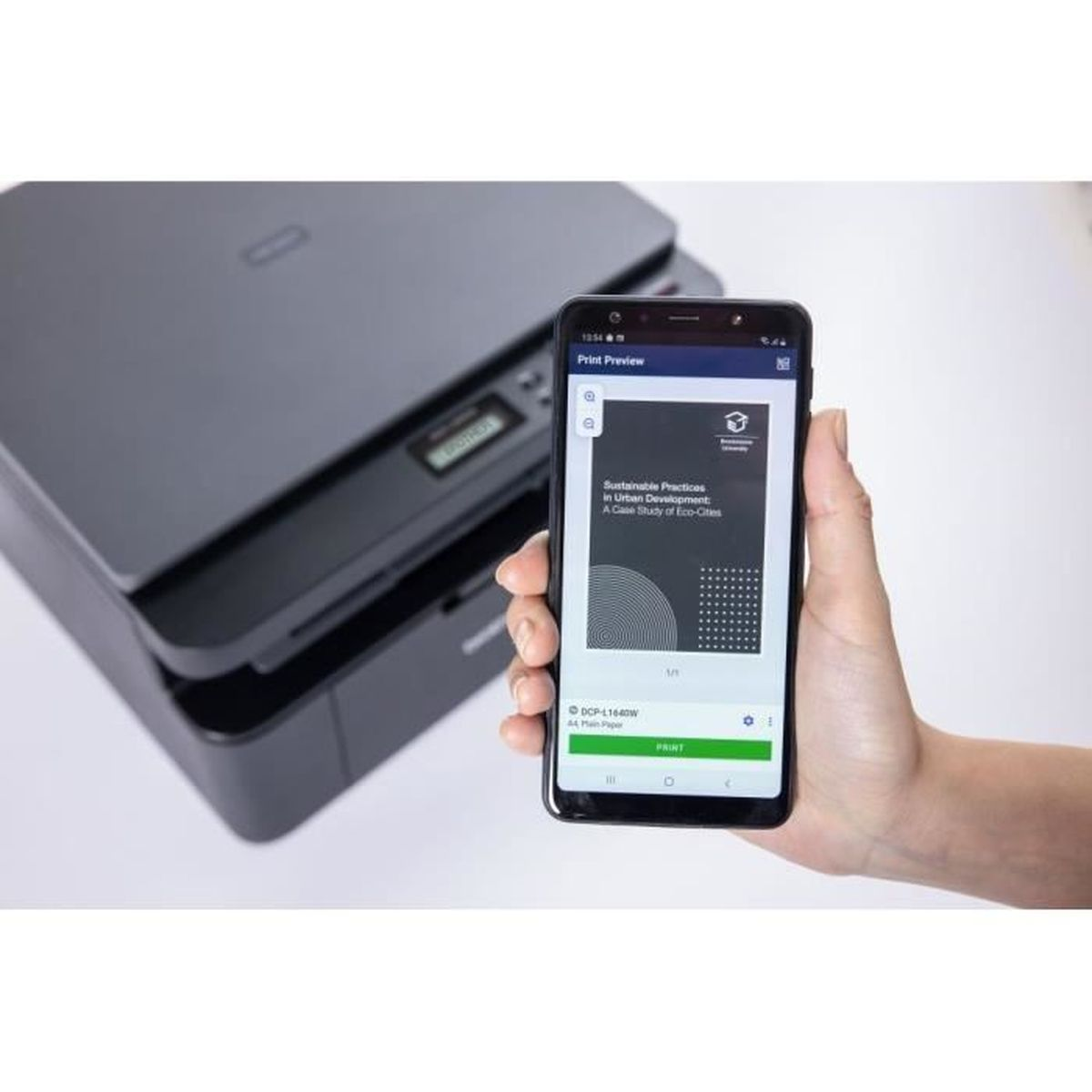 Een hand houdt een telefoon vast met een afdrukvoorbeeld van een document. Een printer staat op de achtergrond.