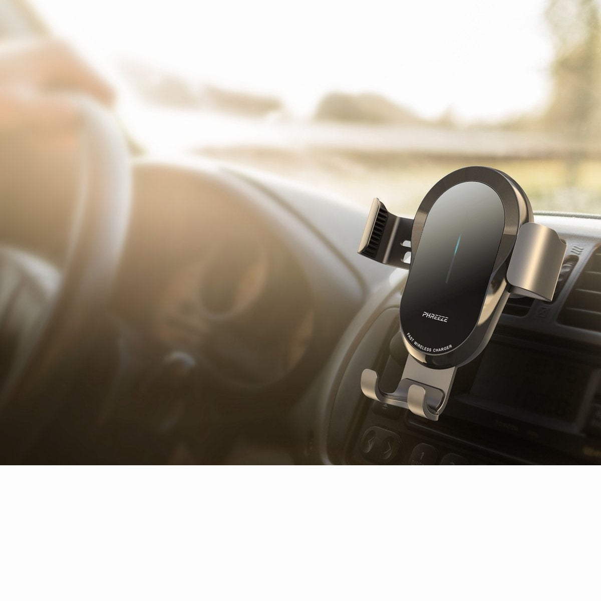 A black and silver wireless phone charger is mounted in a car. The charger is labeled "PHREEZE" and "FAST WIRELESS CHARGER".