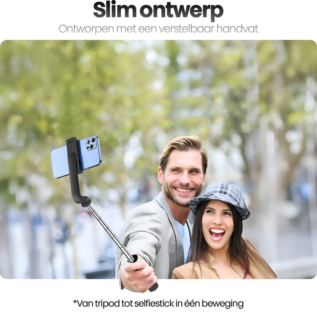 A couple smiling holding a selfie stick with a phone. The woman wears a hat. The background has trees.