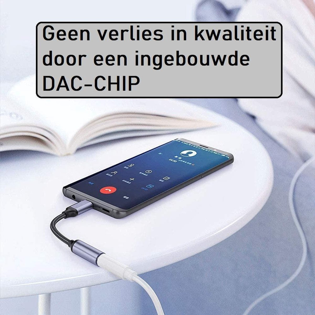 Een smartphone op een witte tafel met een adapter en een witte kabel. Een tekstvak zegt: 'Geen kwaliteitsverlies door een ingebouwde DAC-CHIP'.
