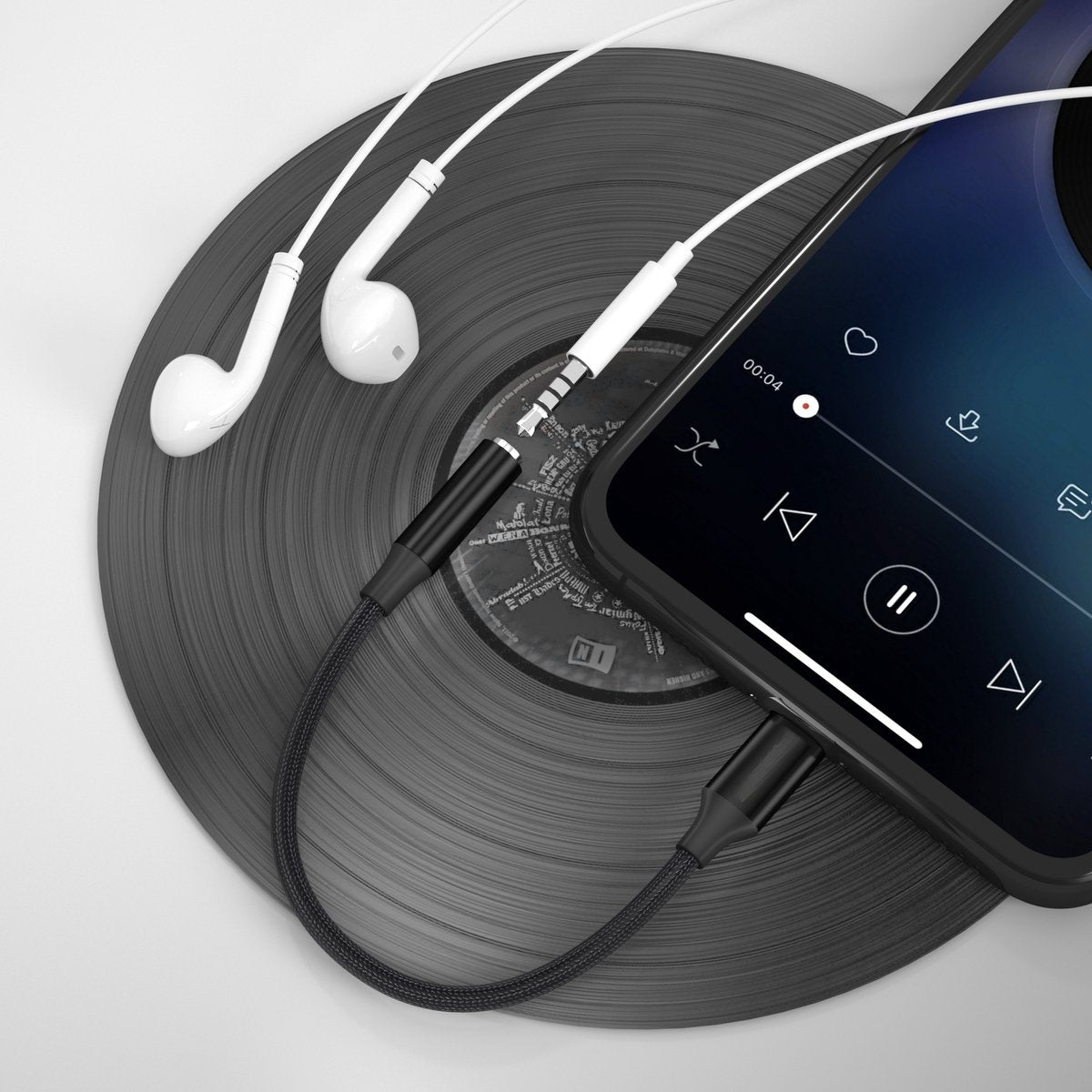 Earphones and a phone connected to a black cable, placed on a vinyl record. The phone displays a music player interface.