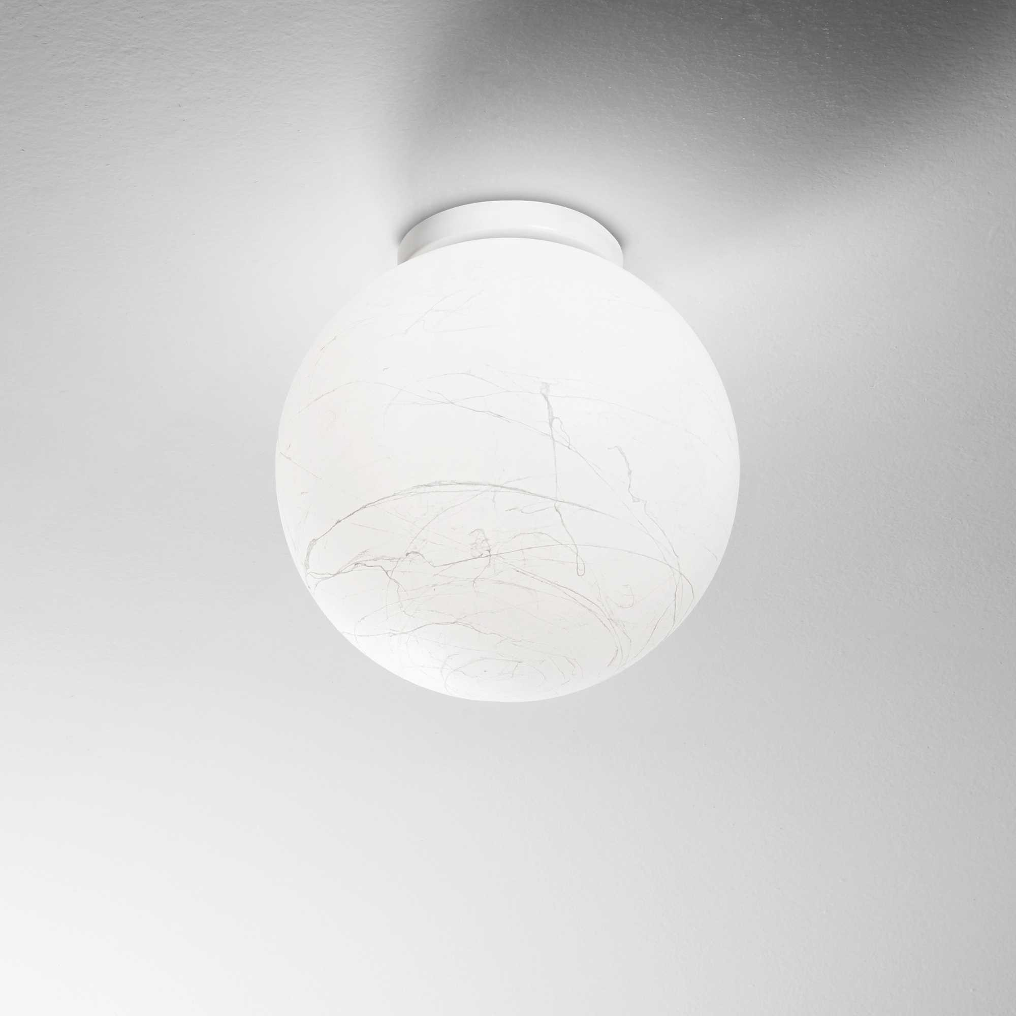 Una plafoniera bianca e rotonda con paralume in vetro marmorizzato è montata su un soffitto bianco.