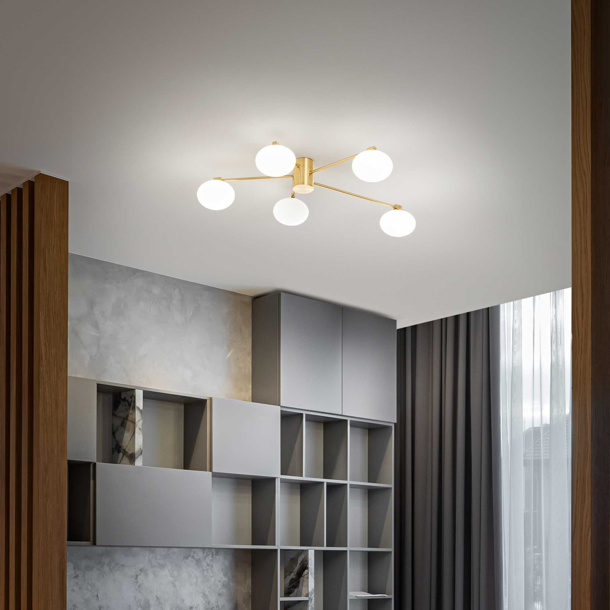 Una stanza moderna con una lampada da soffitto, armadi grigi e tende. La lampada ha cinque lampadine a globo bianche.