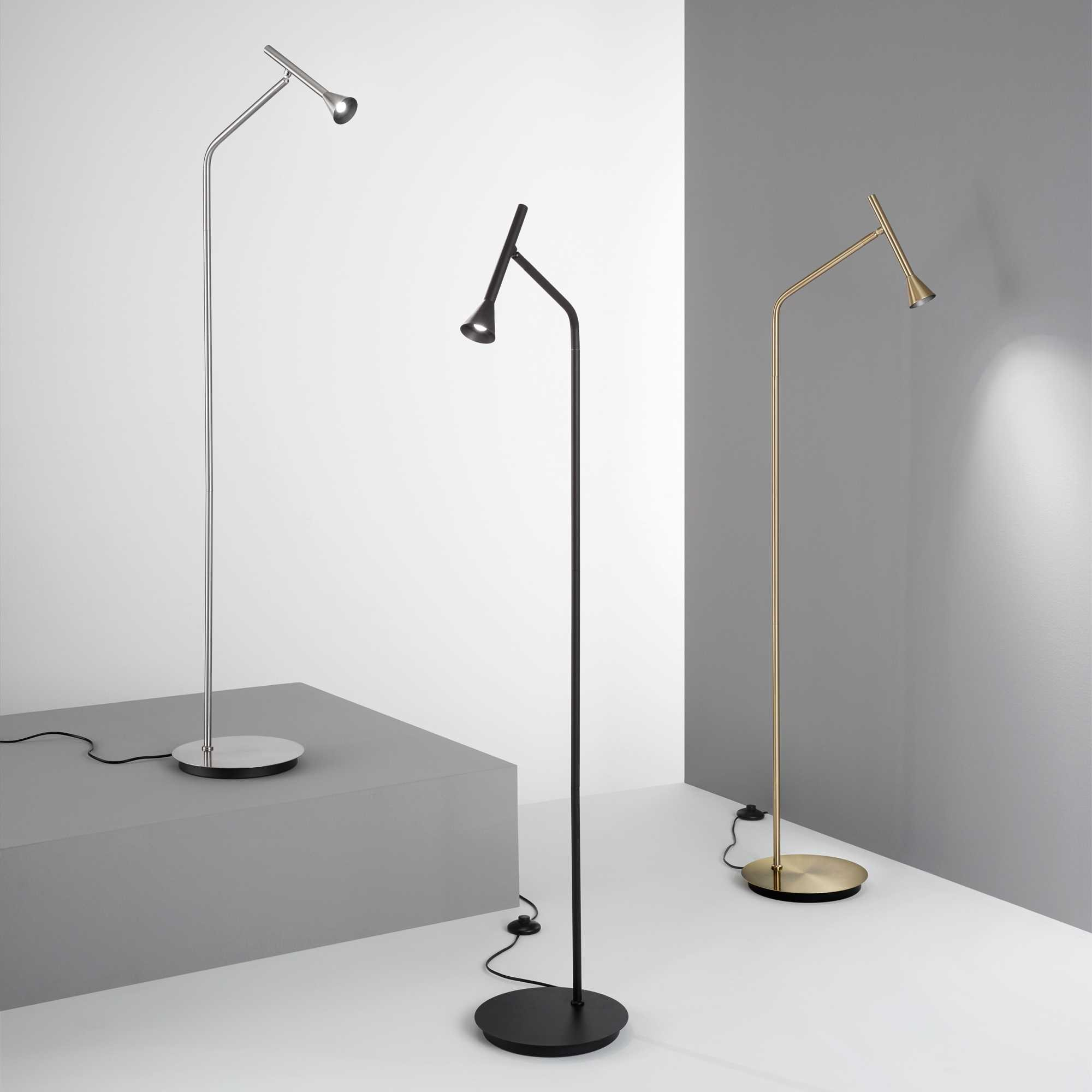 Tre lampade moderne in argento, nero e oro. Ognuna ha una base rotonda e un braccio flessibile con luce a cono.