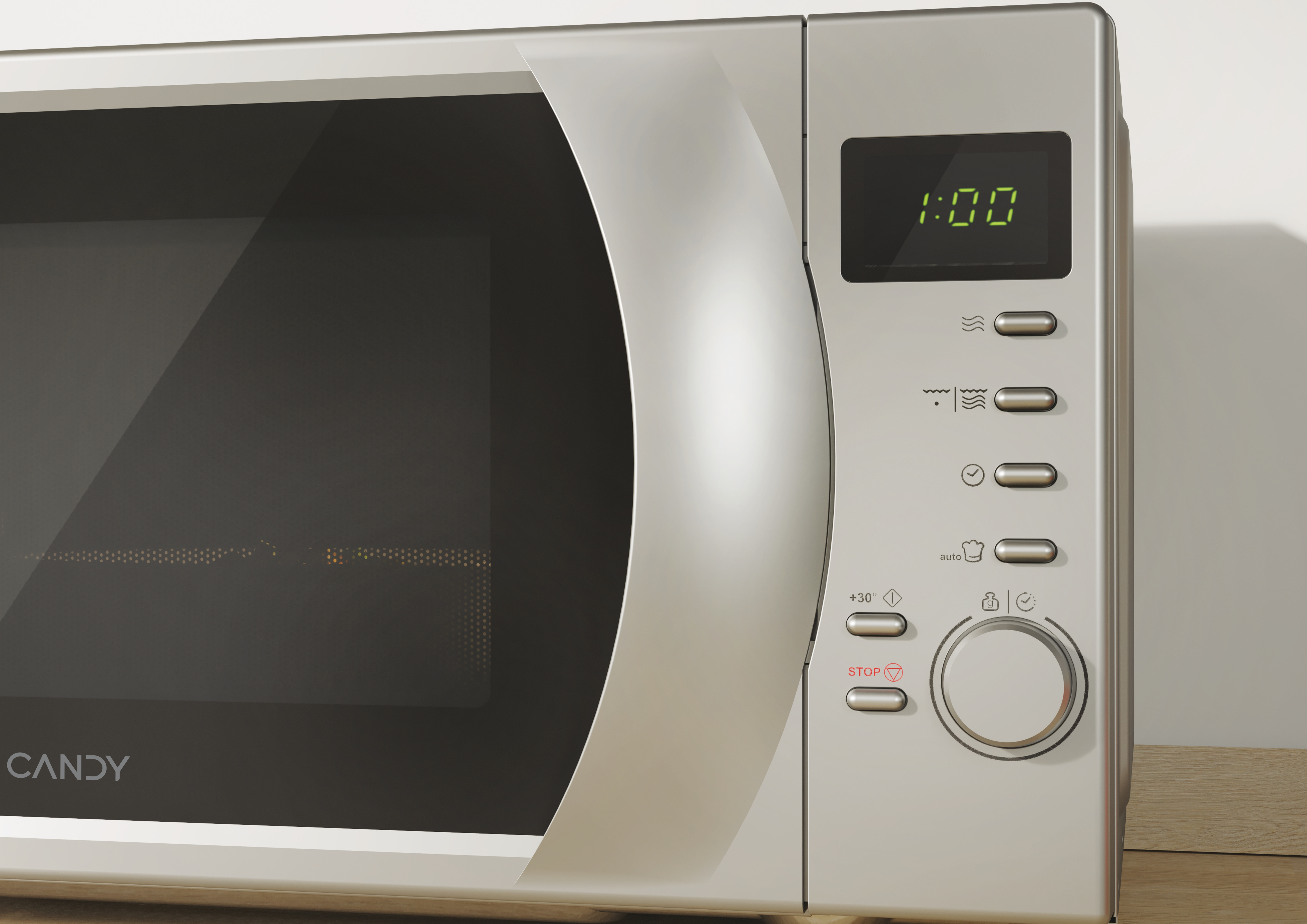 Un forno a microonde argentato con display digitale che mostra 1:00. Ha pulsanti e una manopola. Il marchio è Candy.