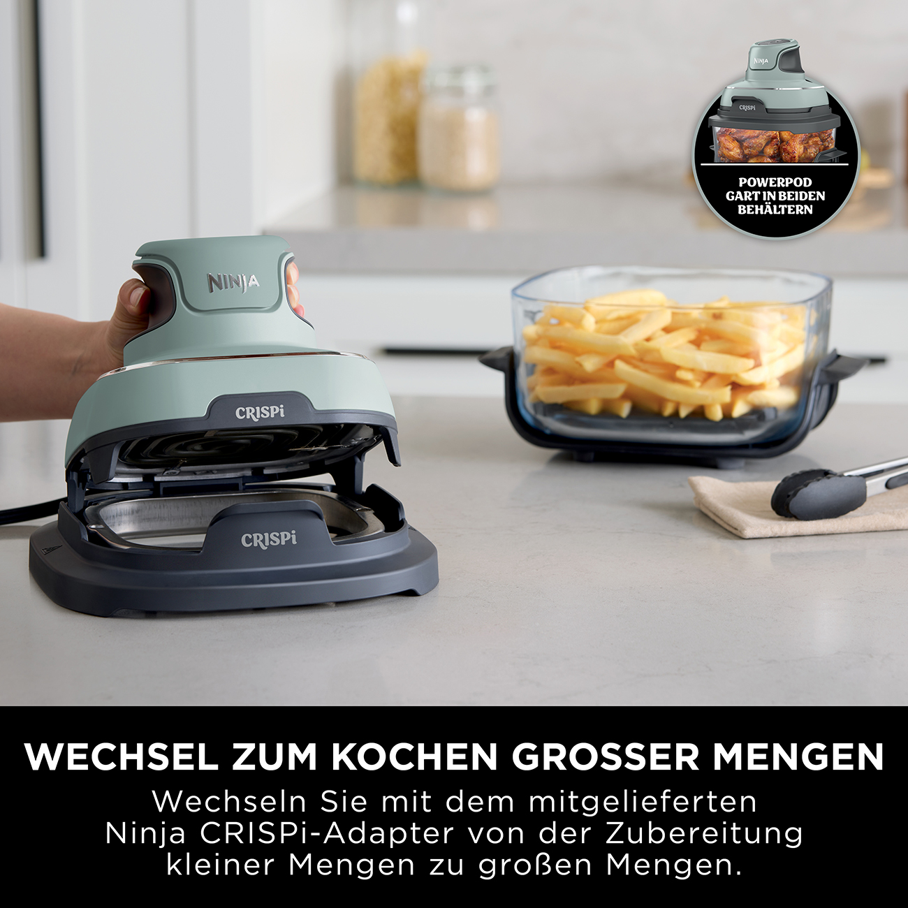 Frytownica beztłuszczowa Ninja Crispi z frytkami i power pod. Frytownica miętowo-zielona i szara. Ręka trzyma frytownicę.