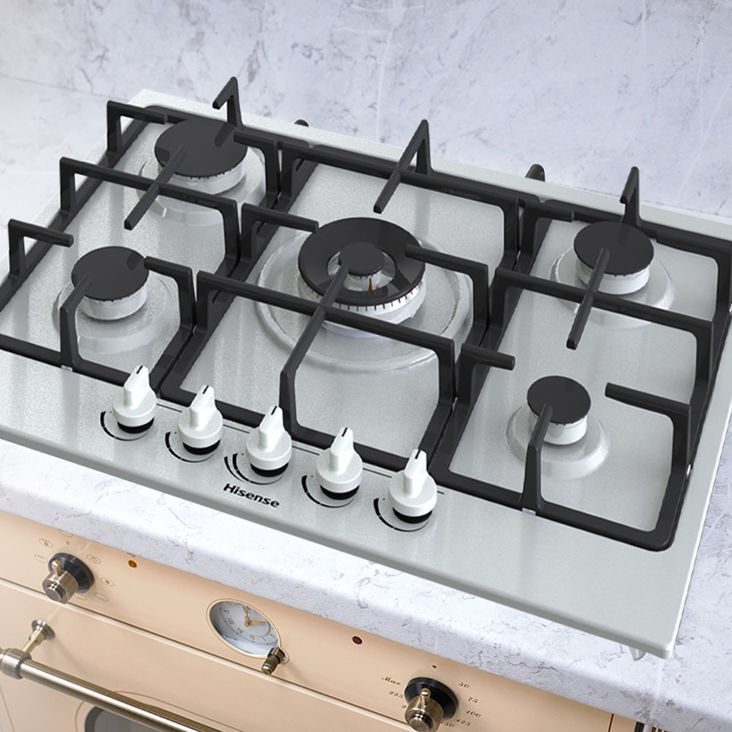 Kuchenka gazowa Hisense z czarnymi rusztami, białymi pokrętłami i czarnymi palnikami. Kuchenka stoi na jasnym blacie. Poniżej znajduje się kremowy piekarnik.