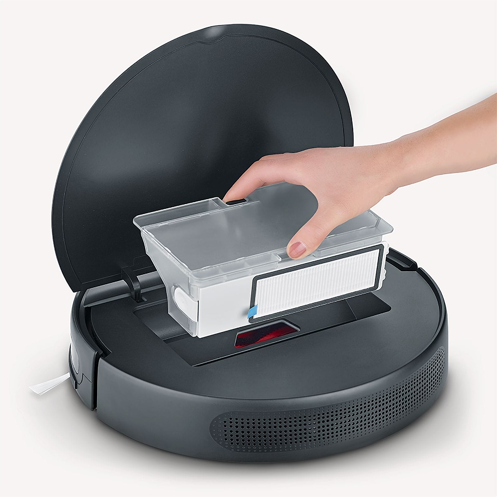 Una mano rimuove un filtro da un robot aspirapolvere grigio scuro. Il coperchio è aperto. Il filtro è bianco con una striscia blu.