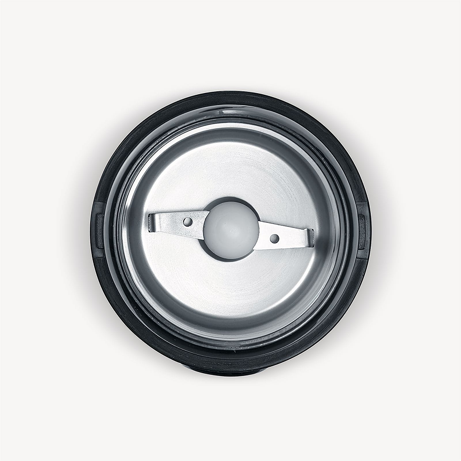 Widok z góry na młynek do kawy. Ma srebrną komorę mielenia, czarną obręcz i ostrze z białą plastikową kulką.