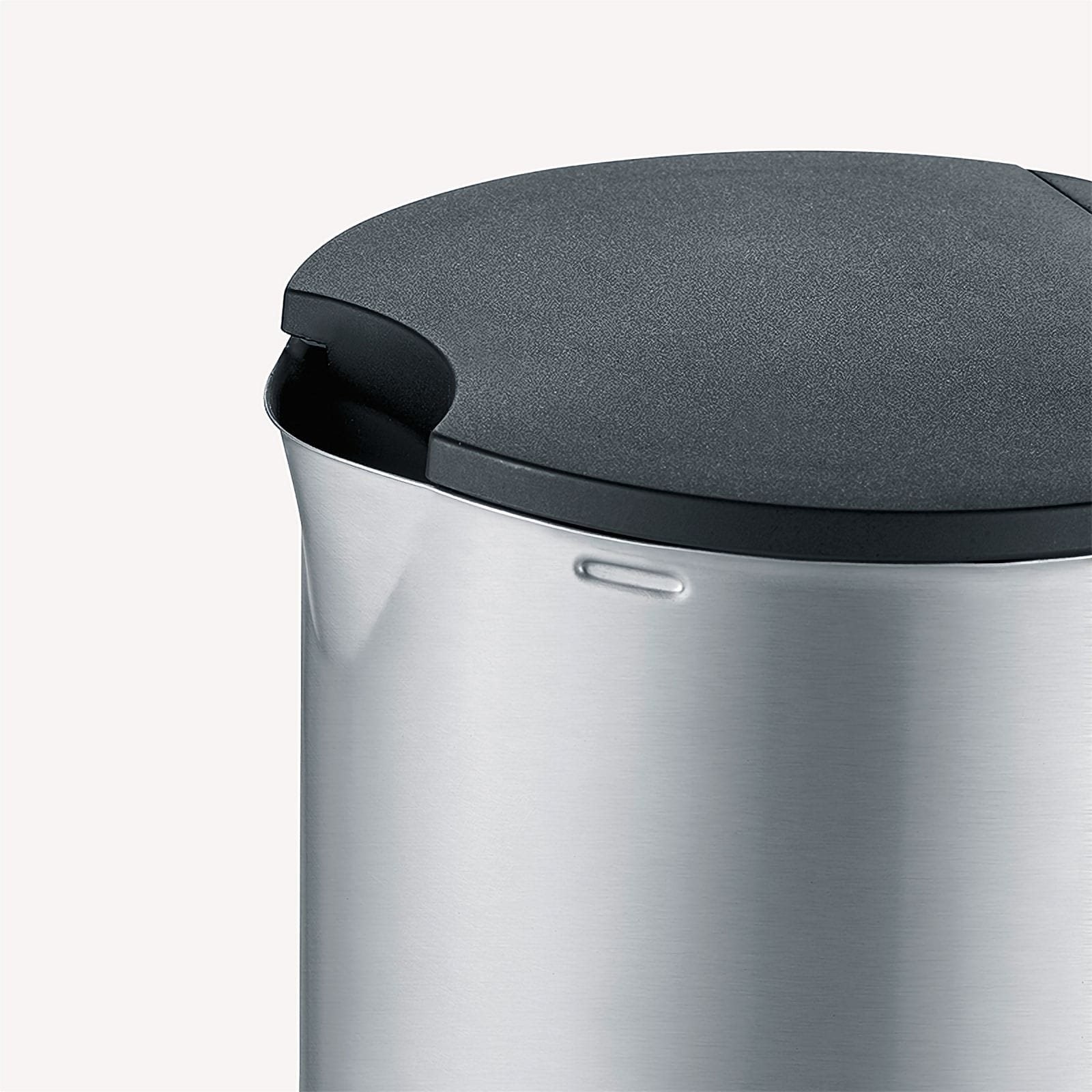 Zbliżenie szczotkowanego metalowego dzbanka z ciemnoszarą pokrywą. Góra ma wycięcie. Białe tło.