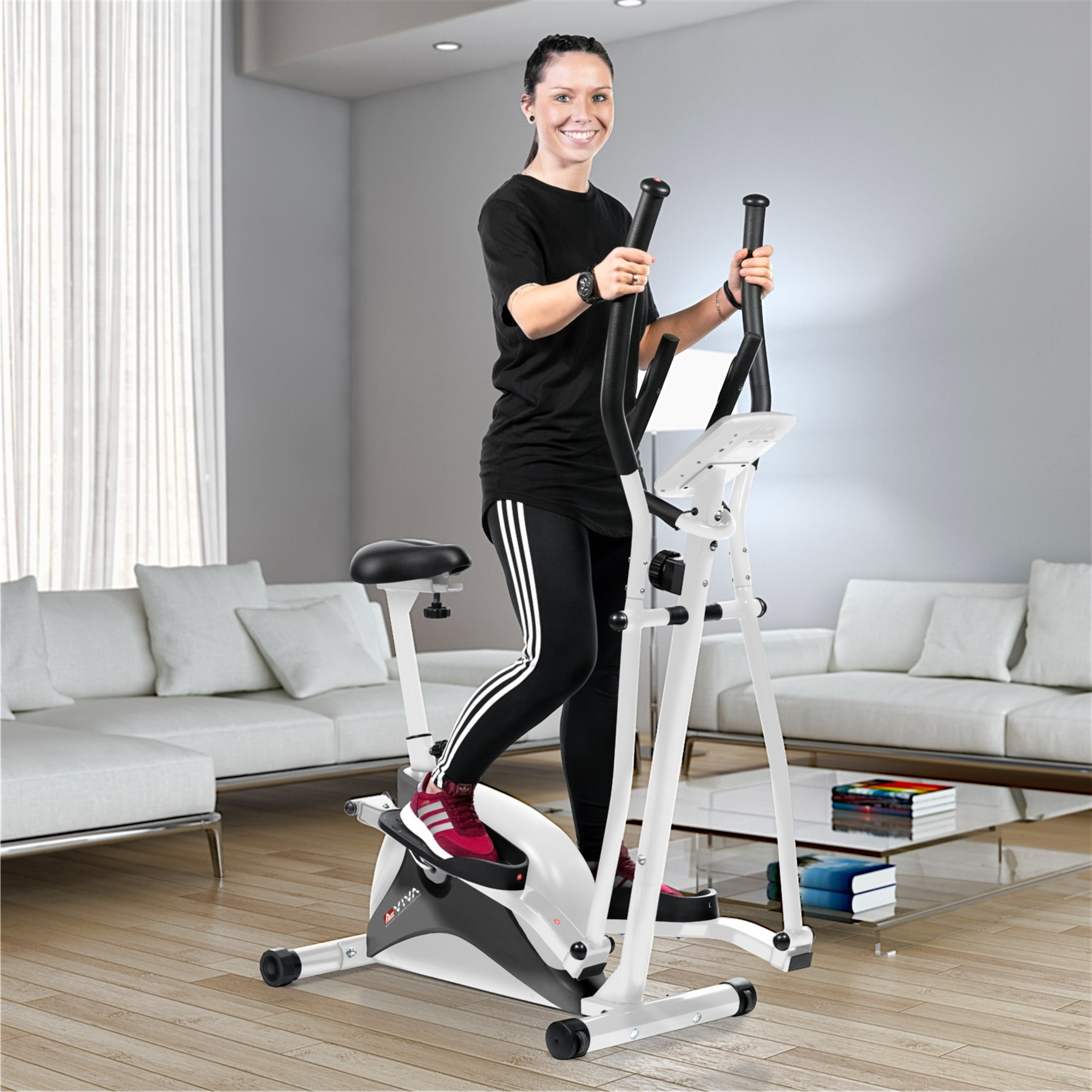 Frau auf einem Crosstrainer, trägt schwarze Sportkleidung, lächelt. Weiße Maschine in einem Wohnzimmer.