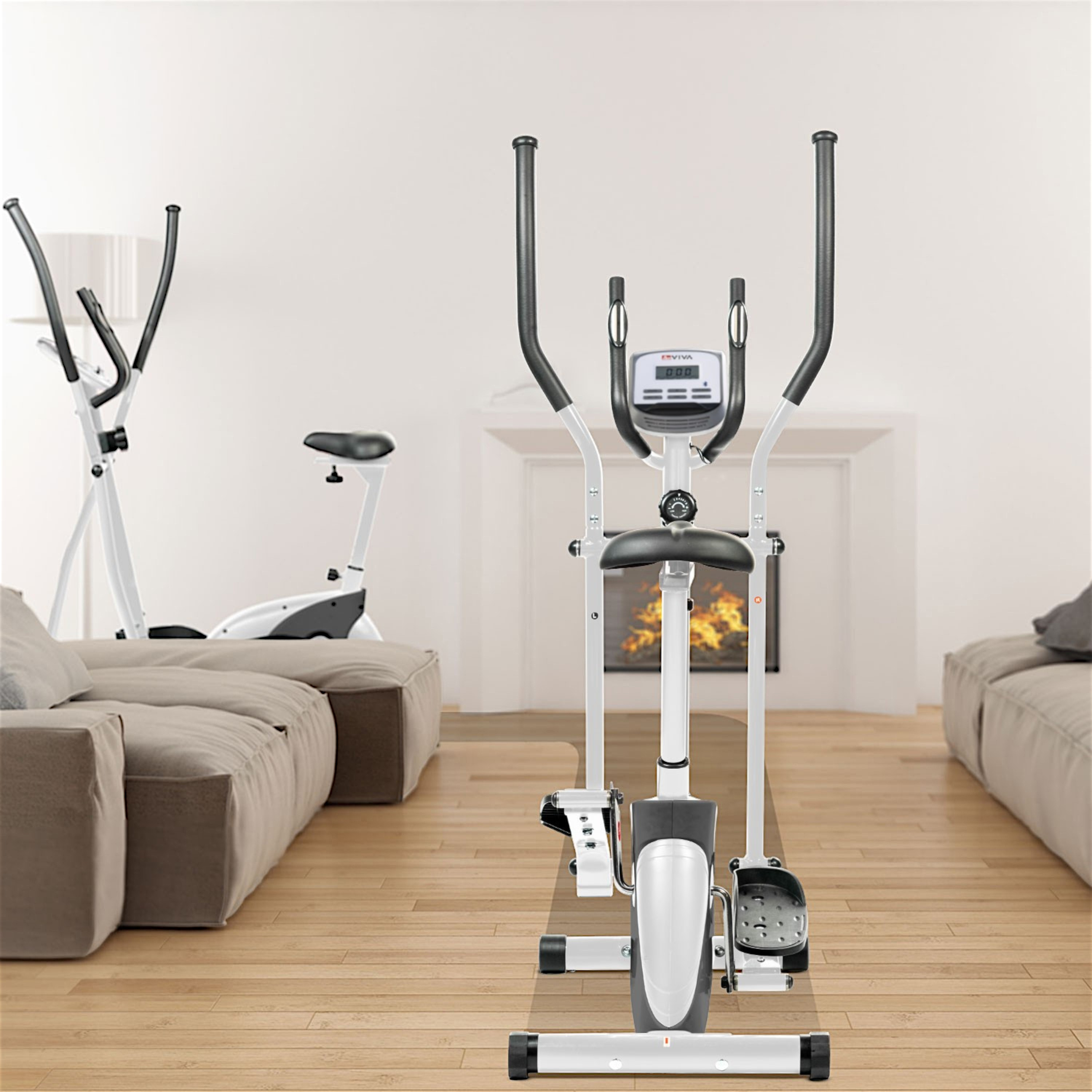 Ellipsentrainer in einem Raum. Im Hintergrund steht ein Heimtrainer. Beige Sofa, Holzboden und Kamin.