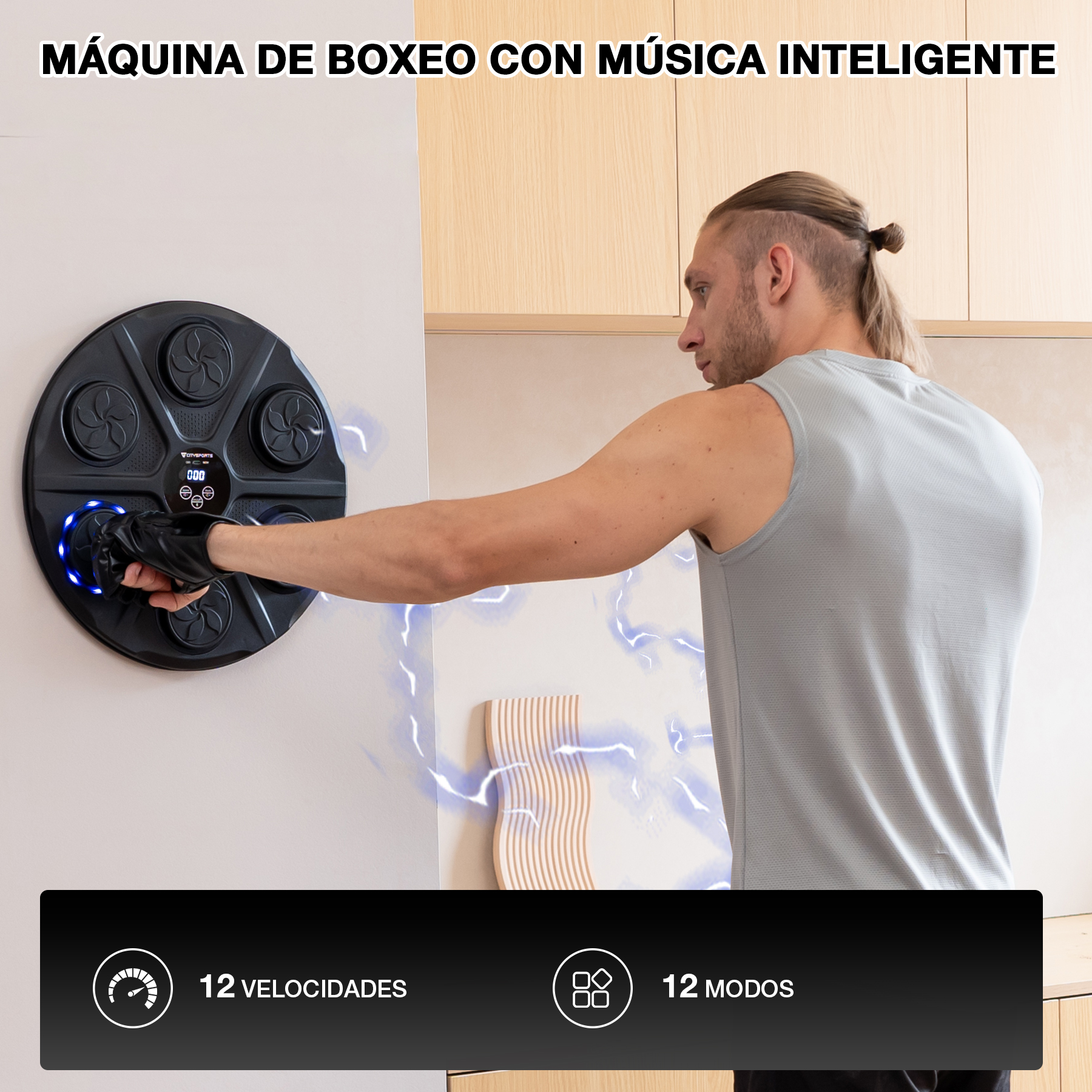 Hombre golpeando una máquina de boxeo negra en una pared. La máquina tiene 12 velocidades y modos. El hombre usa una camiseta sin mangas gris.