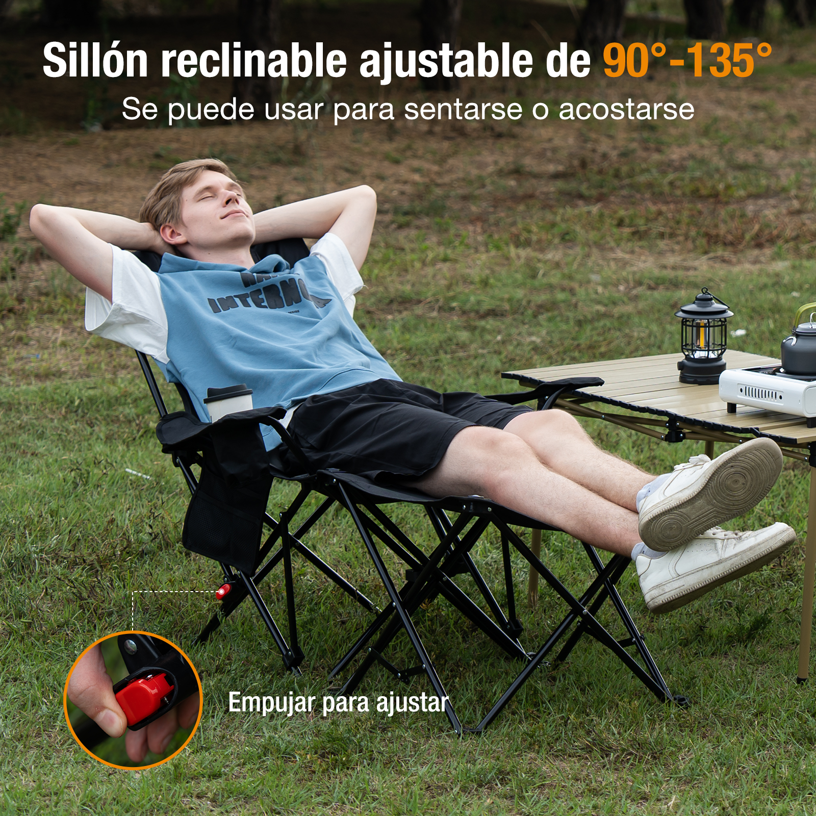 Un hombre se relaja en una silla reclinable negra al aire libre. Una mesa, una linterna y una estufa de camping están en el fondo.
