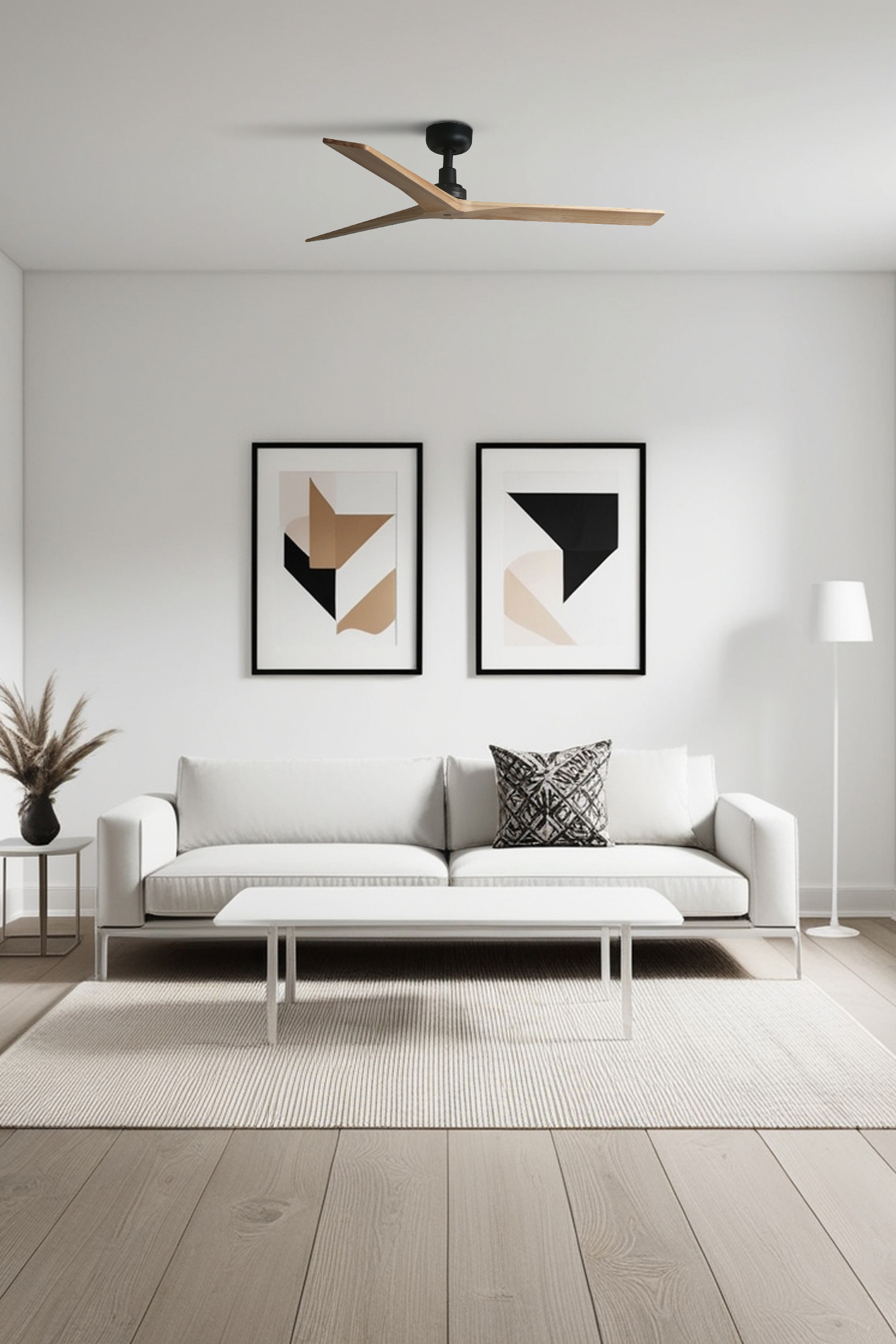 Soggiorno moderno con pareti bianche, divano e tappeto. Include opere d'arte incorniciate, un ventilatore a soffitto e una lampada da terra. Pavimento in legno.