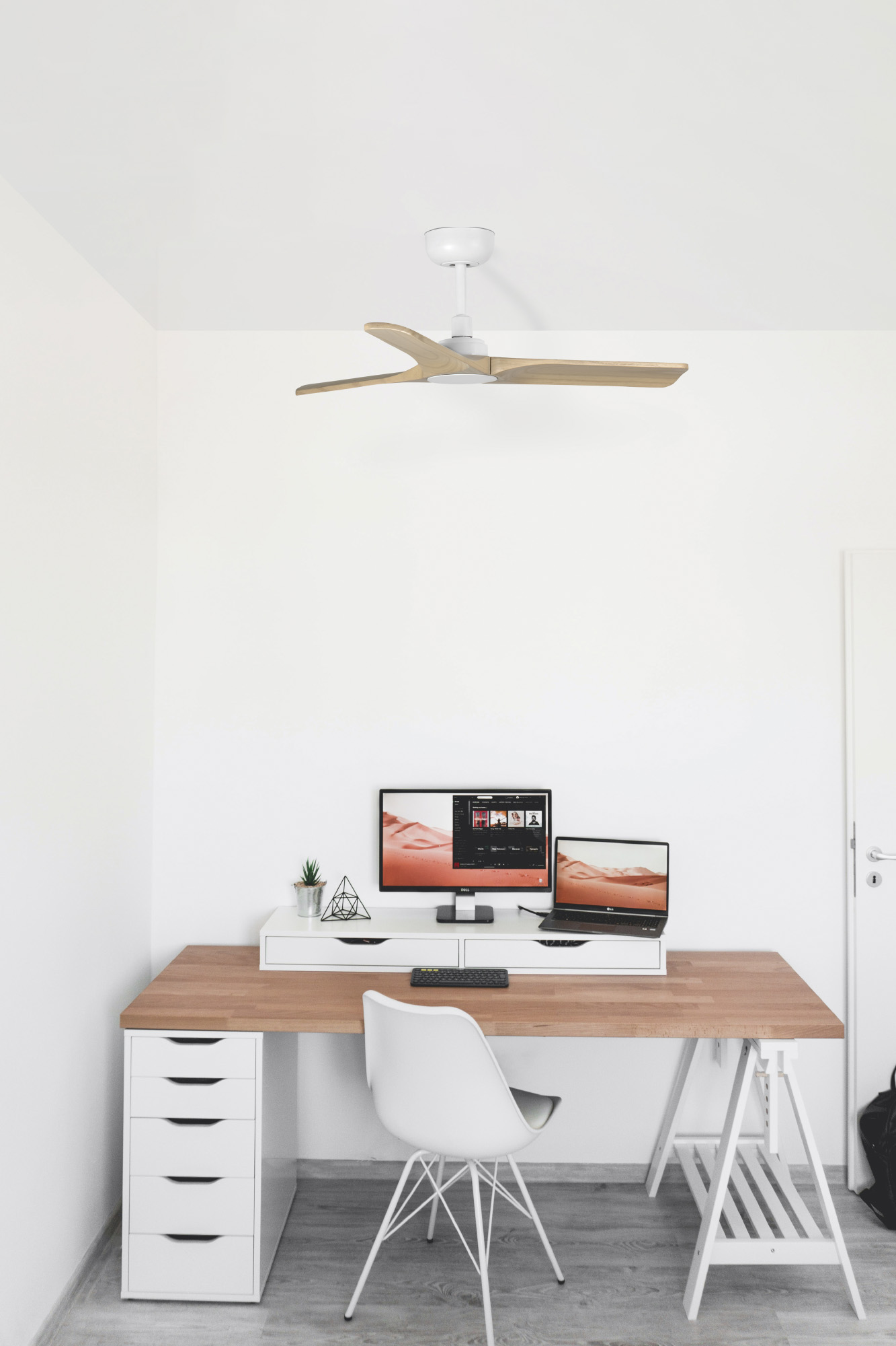 Moderne Büroeinrichtung mit Schreibtisch, Computer, Laptop und Stuhl. Über dem Schreibtisch befindet sich ein Deckenventilator.