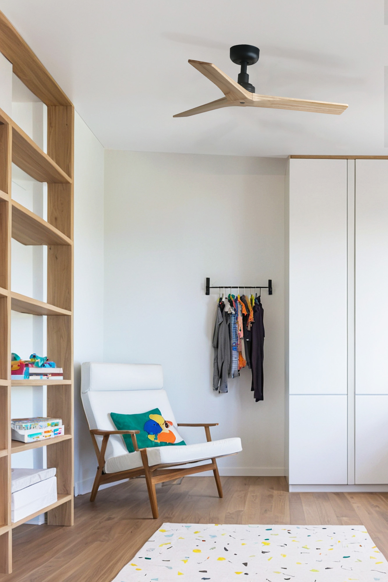 Una stanza moderna con sedia bianca, libreria in legno, ventilatore a soffitto e tappeto colorato sul pavimento.