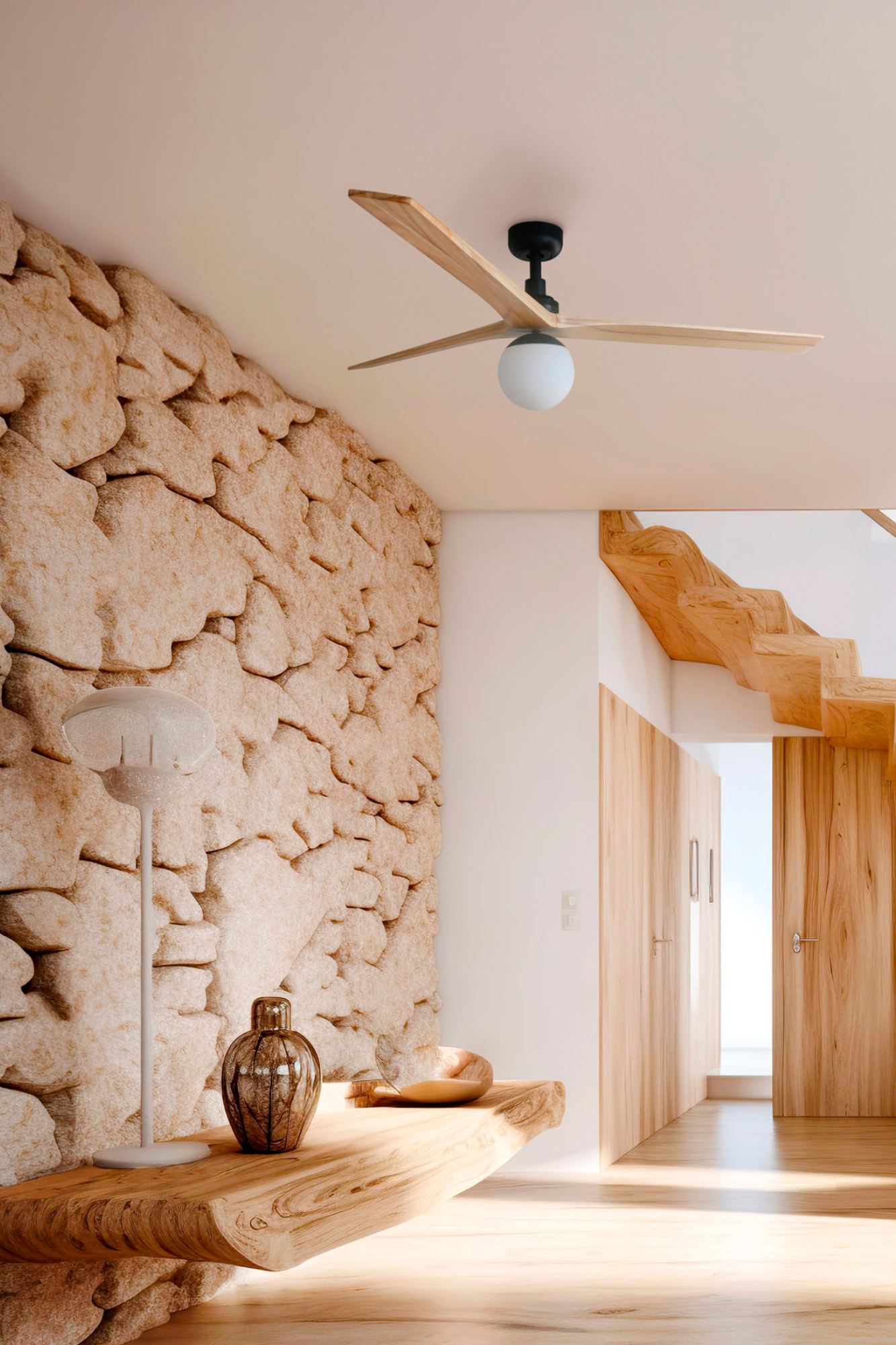 Innenraum mit Steinmauer, Holztreppe und -türen, Deckenventilator, Lampe und Dekorationsgegenständen auf einem Holzregal.