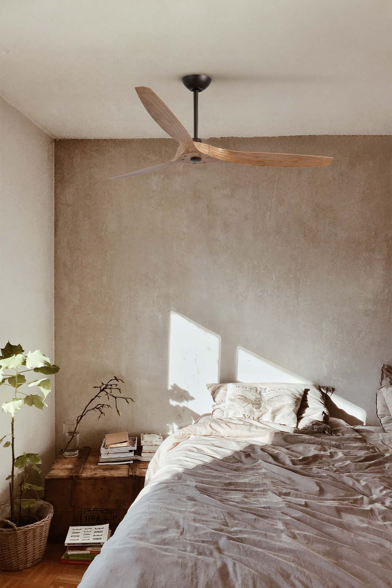 Schlafzimmer mit Deckenventilator aus Holz, Bett und Pflanzen. Sonnenlicht scheint durch das Fenster und beleuchtet den Raum.