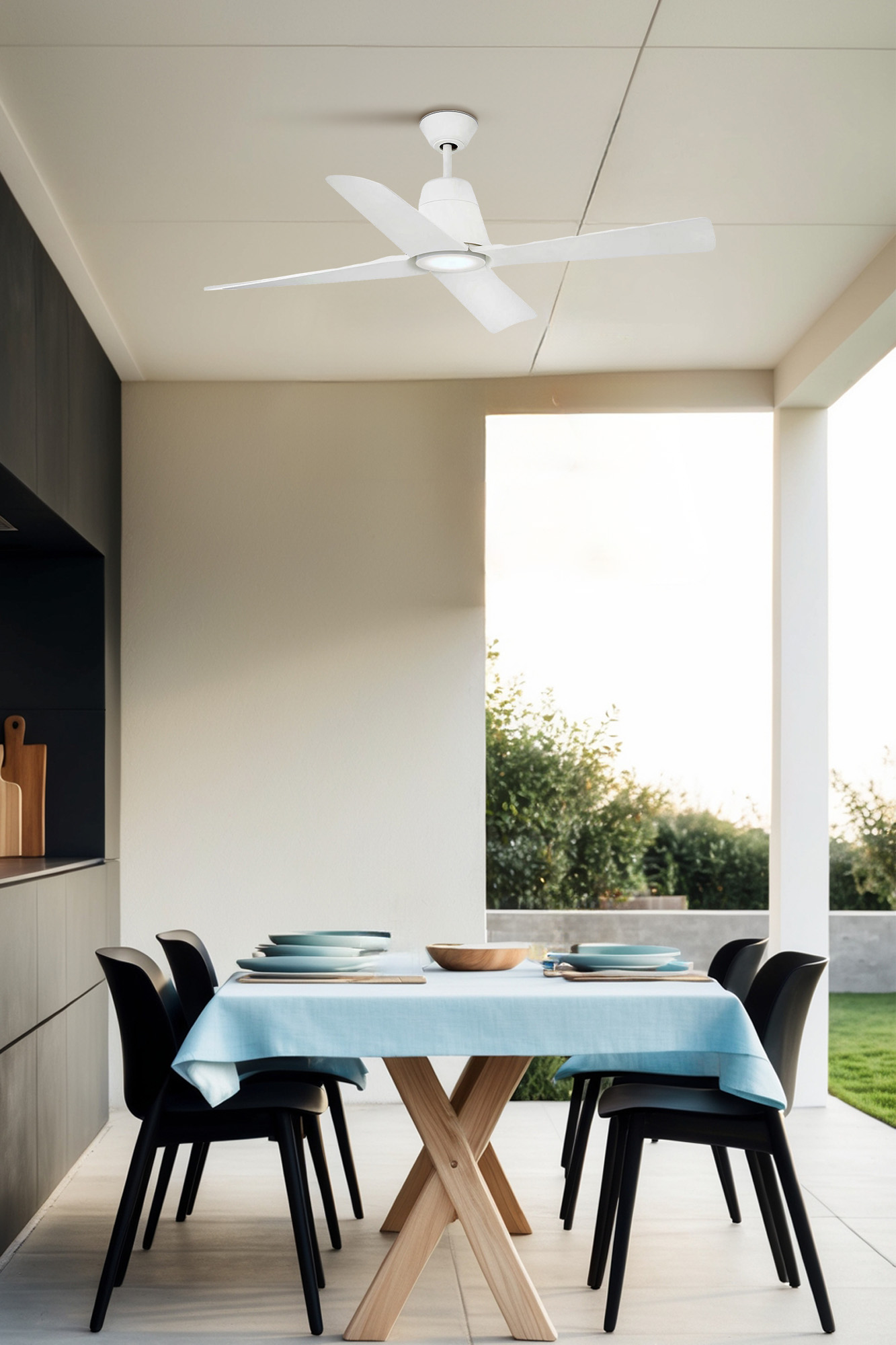 Una zona pranzo con tavolo, sedie e ventilatore a soffitto. Il tavolo è apparecchiato con piatti e una tovaglia blu.