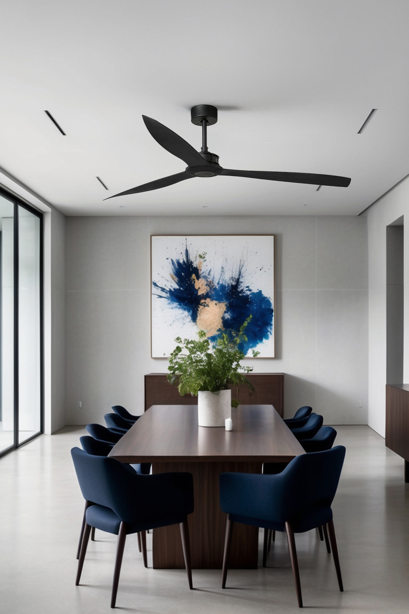 Una sala da pranzo moderna con un tavolo e sedie in legno scuro. Un ventilatore è appeso al soffitto. Sono esposte opere d'arte e piante.