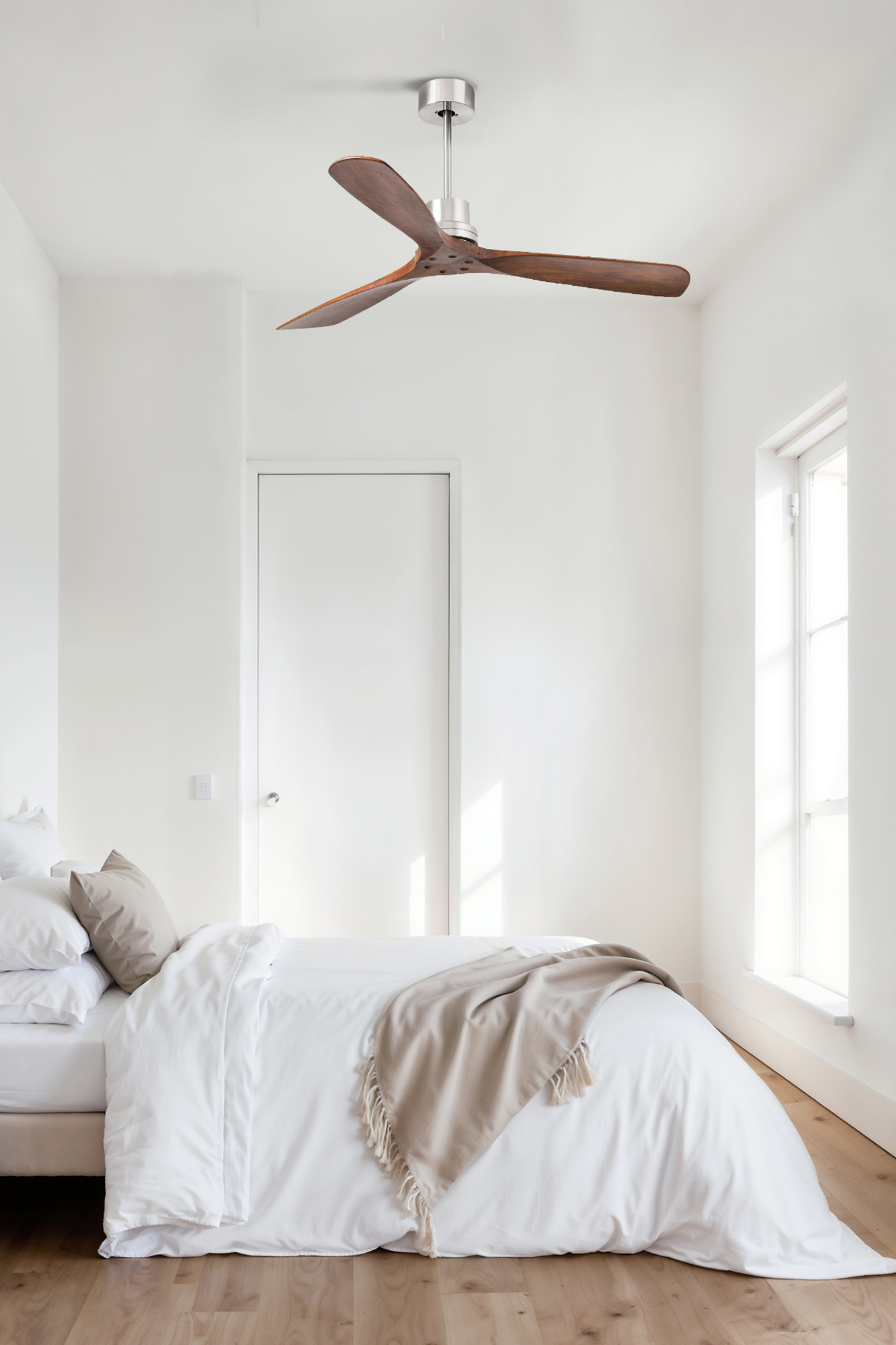 Schlafzimmer mit Deckenventilator aus Holz, weißer Bettwäsche und Fenster. Das Zimmer hat Holzböden und eine Tür.
