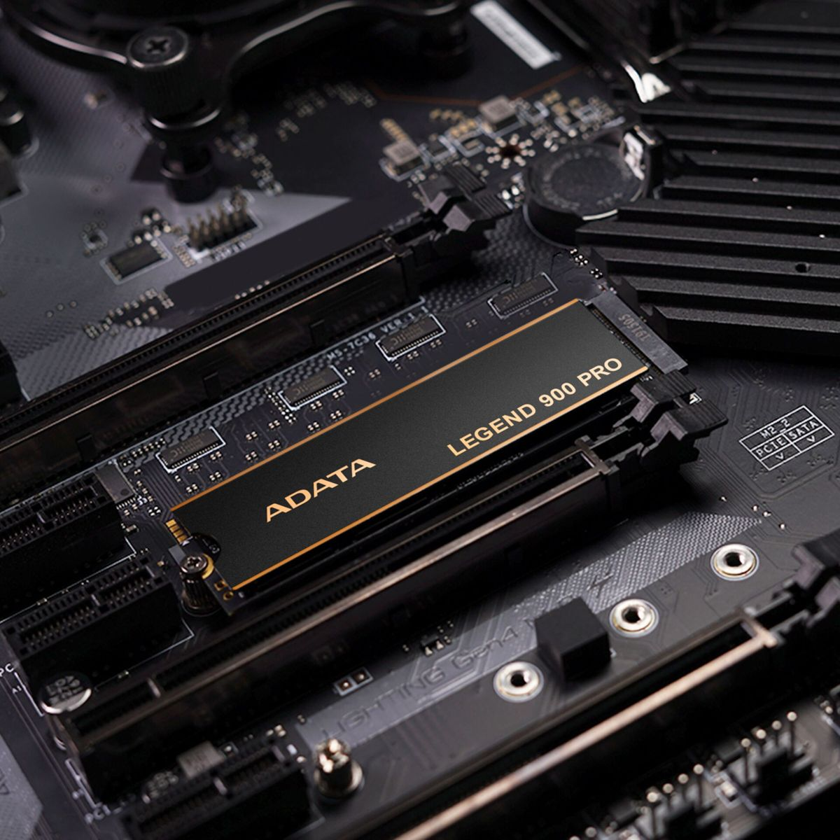 Dysk SSD ADATA Legend 900 Pro zainstalowany na czarnej płycie głównej. Dysk SSD jest czarny i złoty. Tło pokazuje inne komponenty komputera.