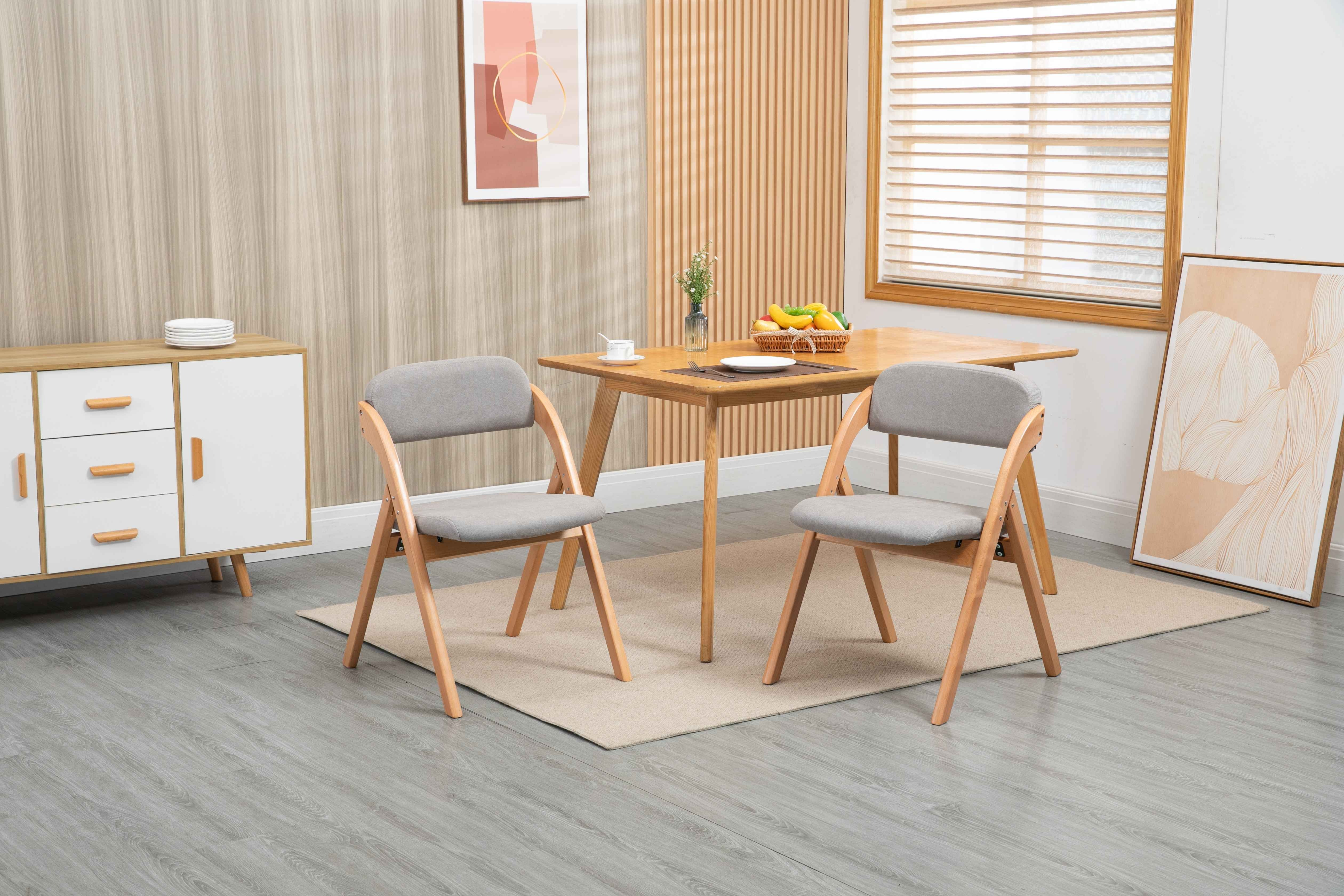 Ein Esszimmer mit zwei Stühlen, einem Tisch und einem Schrank. Ein Gemälde an der Wand und ein Fenster rechts.