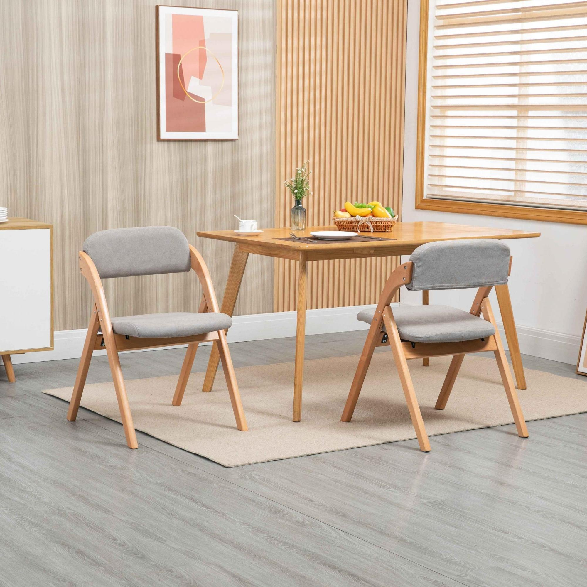 Ein Esszimmer mit Holztisch, zwei Stühlen und Fenster. Auf dem Tisch steht ein Obstkorb.