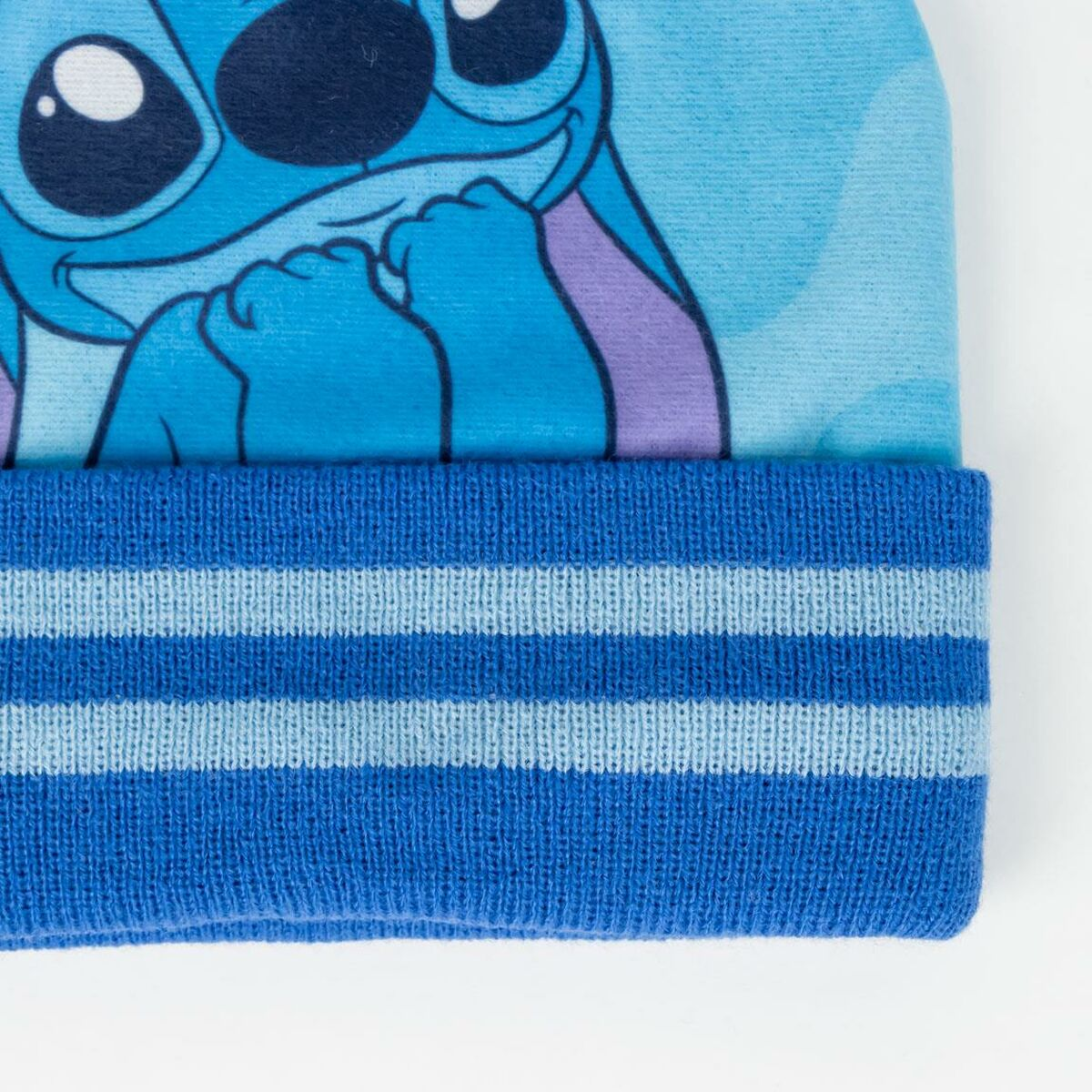 Eine blaue Mütze mit Stitchs Gesicht darauf. Die Mütze hat ein gestreiftes Band am unteren Rand und einen hellblauen Hintergrund.