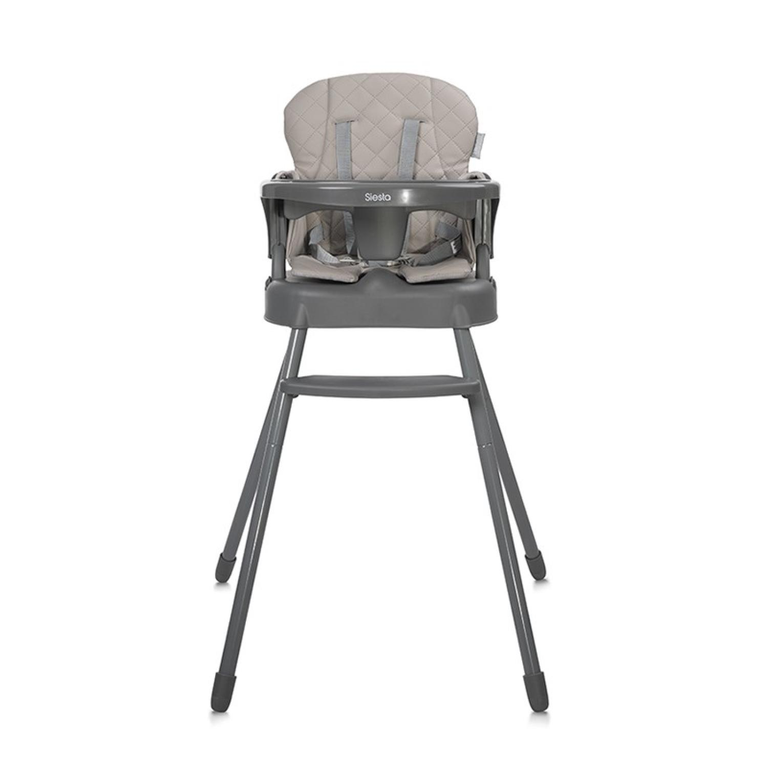 Una trona gris, con asiento y respaldo acolchados y cinturones de seguridad. La silla tiene una estructura metálica.