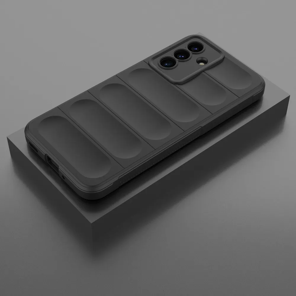 Un étui de téléphone noir avec une découpe pour l'appareil photo et des rayures texturées est placé sur une plateforme noire sur fond gris.