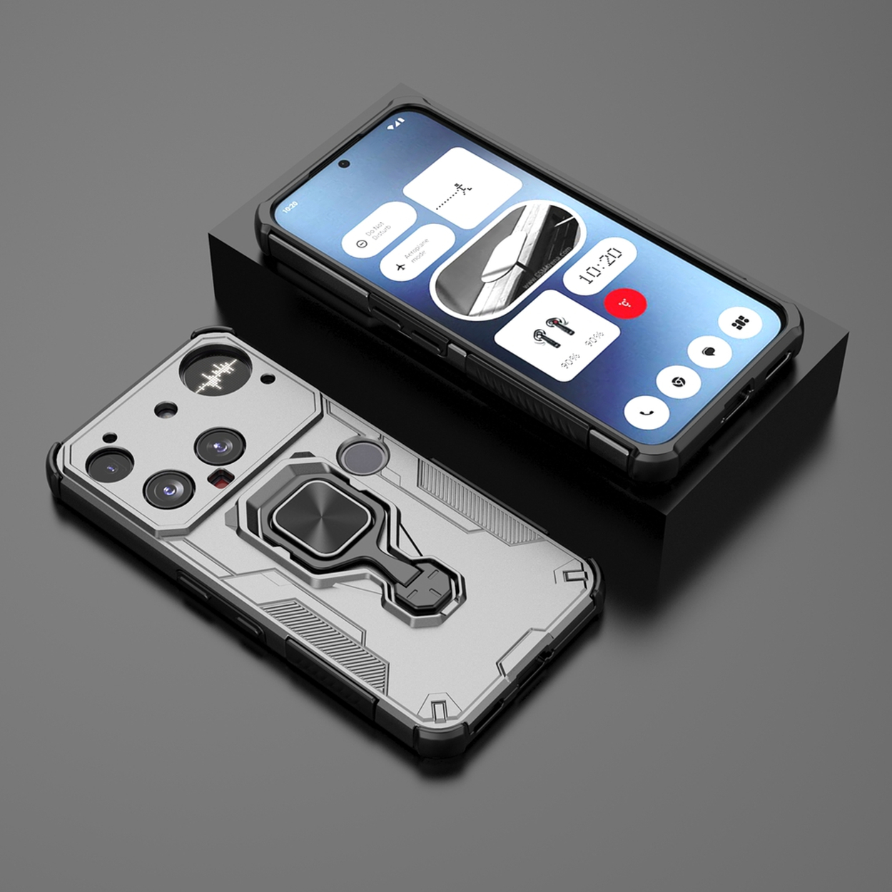 Deux smartphones avec des étuis de protection sur une surface noire. L'un affiche un panneau de contrôle, l'autre a un étui argenté avec un anneau.