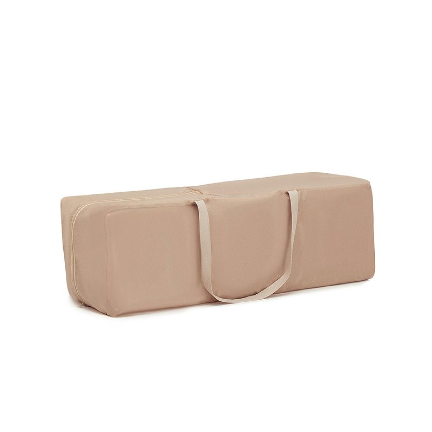 Eine beige rechteckige Tasche mit Reißverschluss und Griff vor weißem Hintergrund.