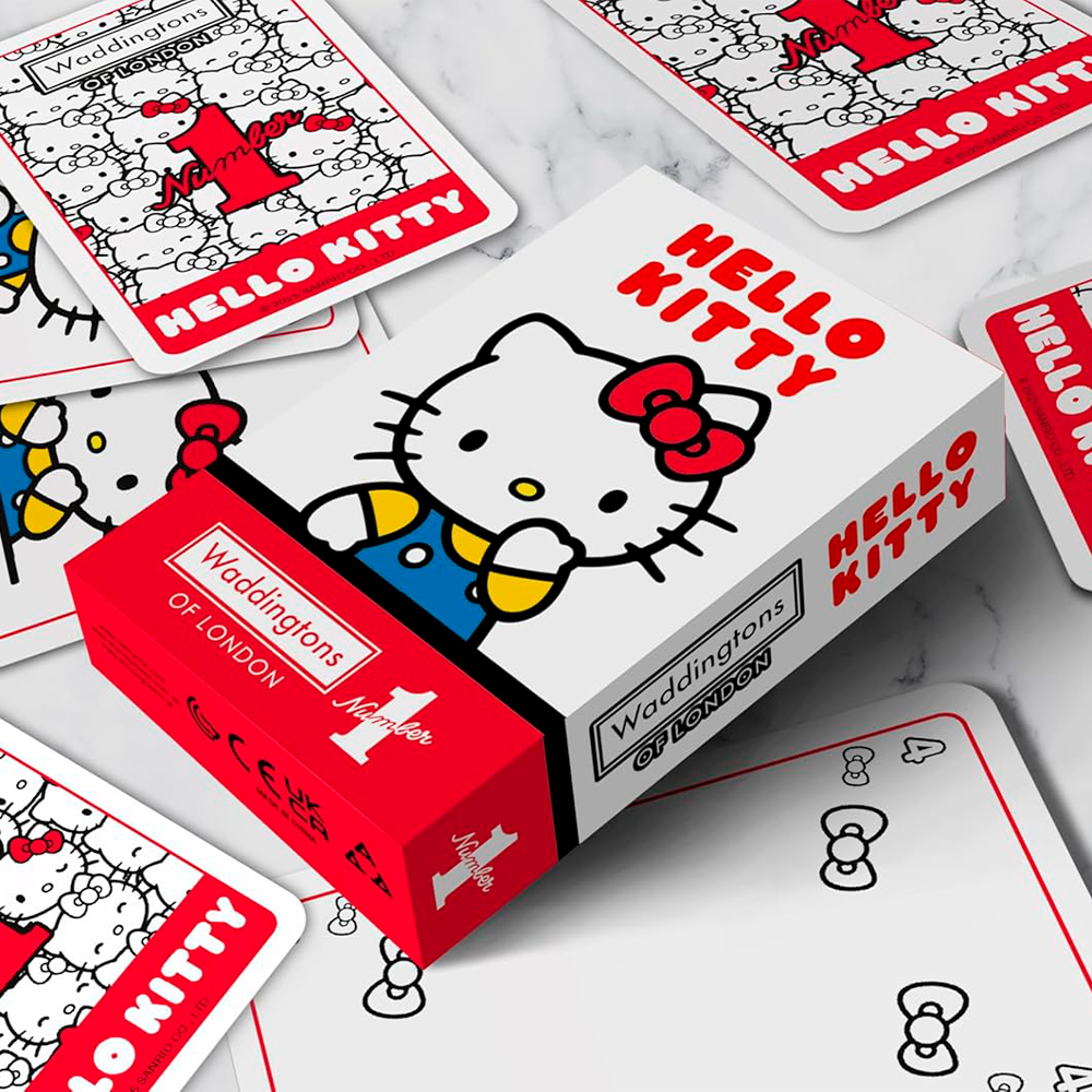 Carte da gioco di Hello Kitty e una scatola. La scatola e le carte presentano Hello Kitty. La scatola è rossa e bianca. Le carte sono sparse.