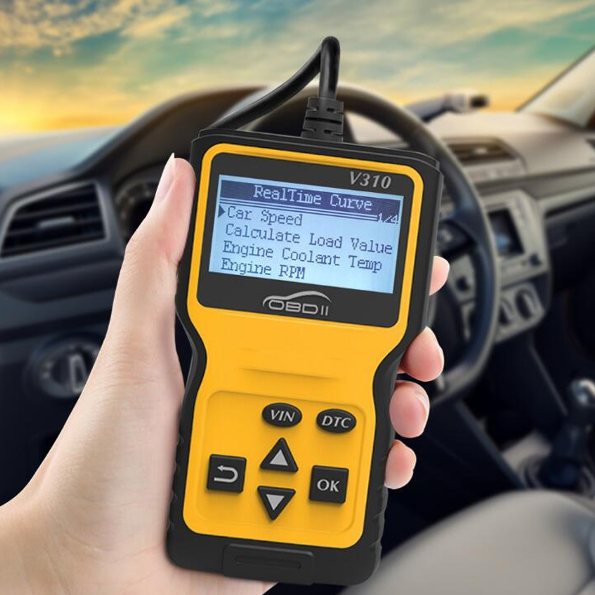Eine Hand hält ein gelb-schwarzes OBDII-Scanner, das Fahrzeugdaten anzeigt. Im Hintergrund sind Lenkrad und Armaturenbrett zu sehen.