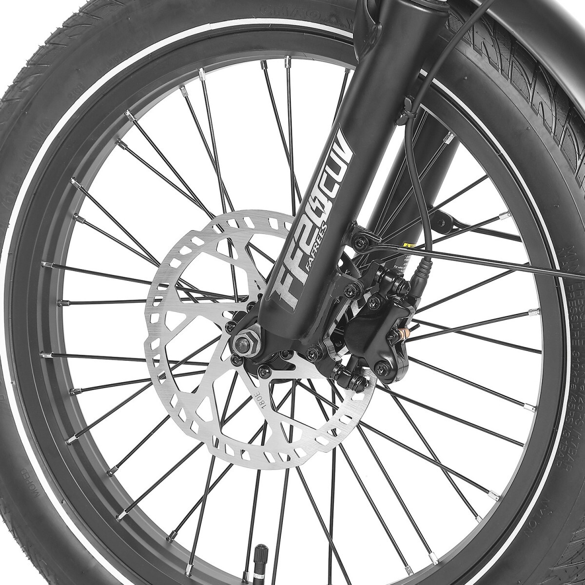 Zbliżenie koła roweru. Czarna opona, szprychy i hamulec tarczowy widoczne na białym tle. Na widelcu napis 'FAFrees'.