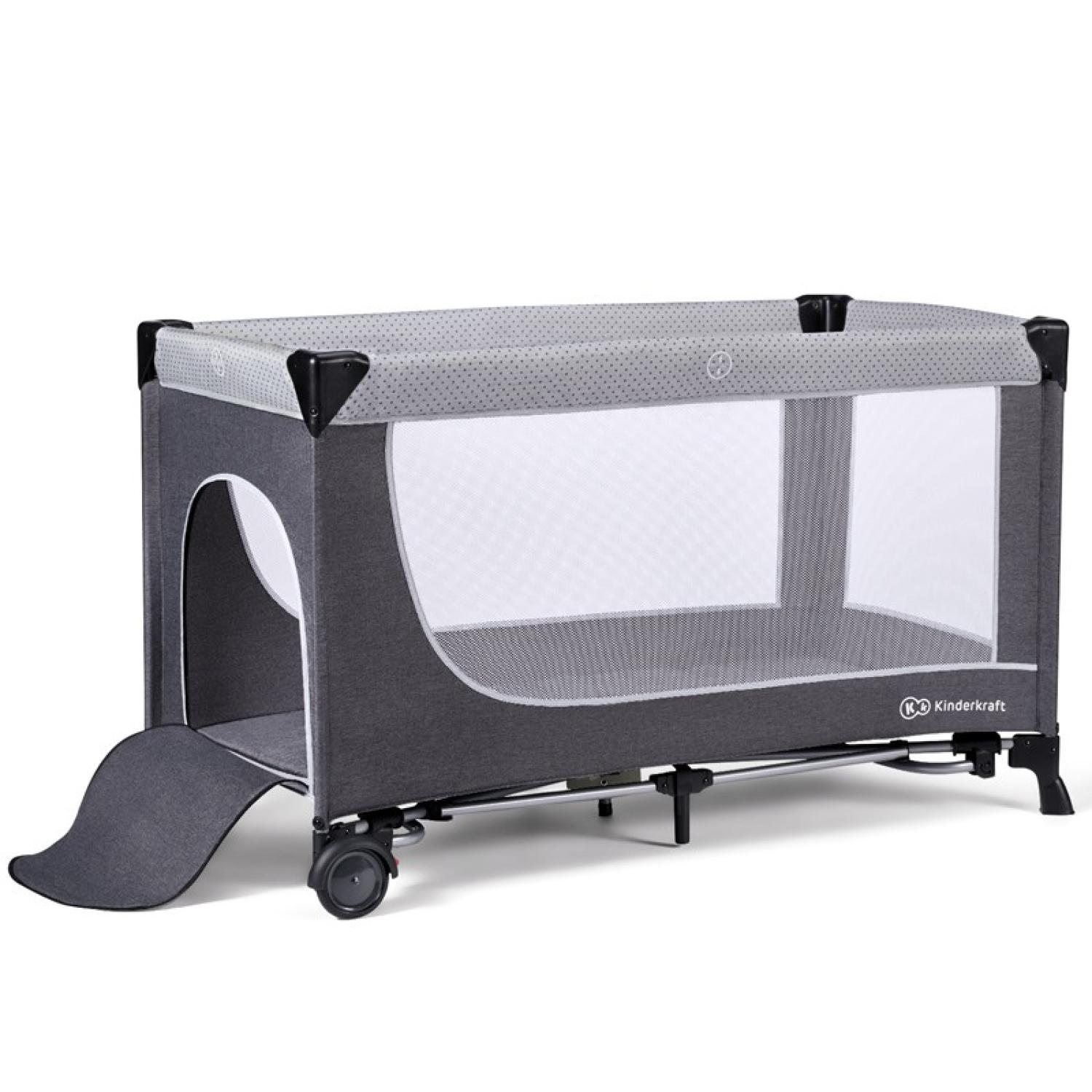 Una cuna de viaje Kinderkraft gris y blanca. Cuenta con laterales de malla, una entrada plegable y una barra superior gris punteada.