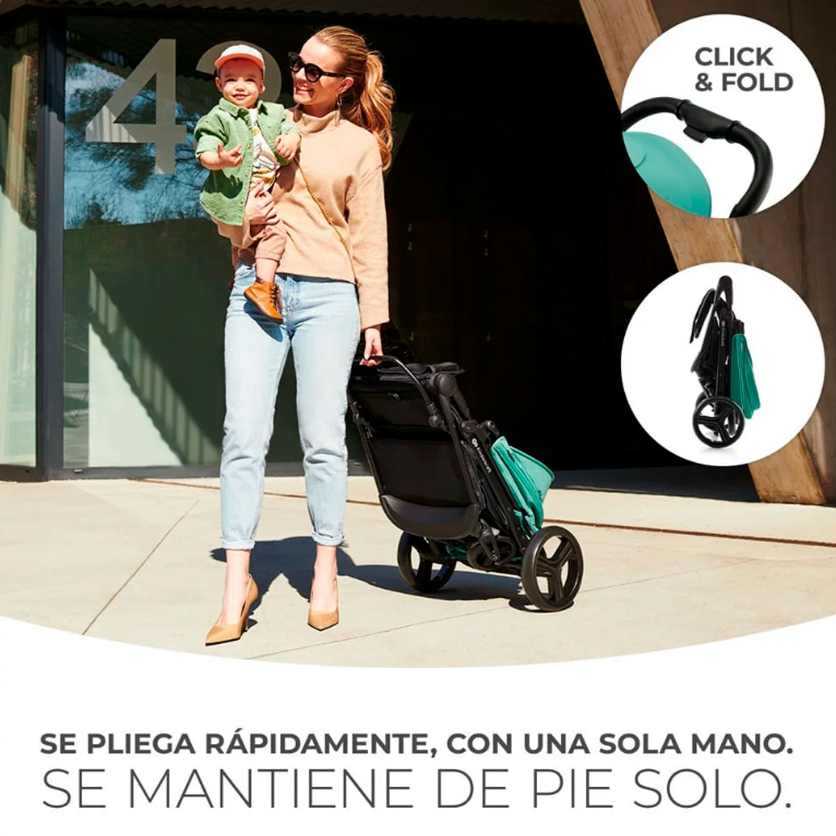 Una mujer sostiene a un bebé junto a un cochecito. El cochecito es negro y turquesa. El texto dice: 'CLICK & FOLD'.