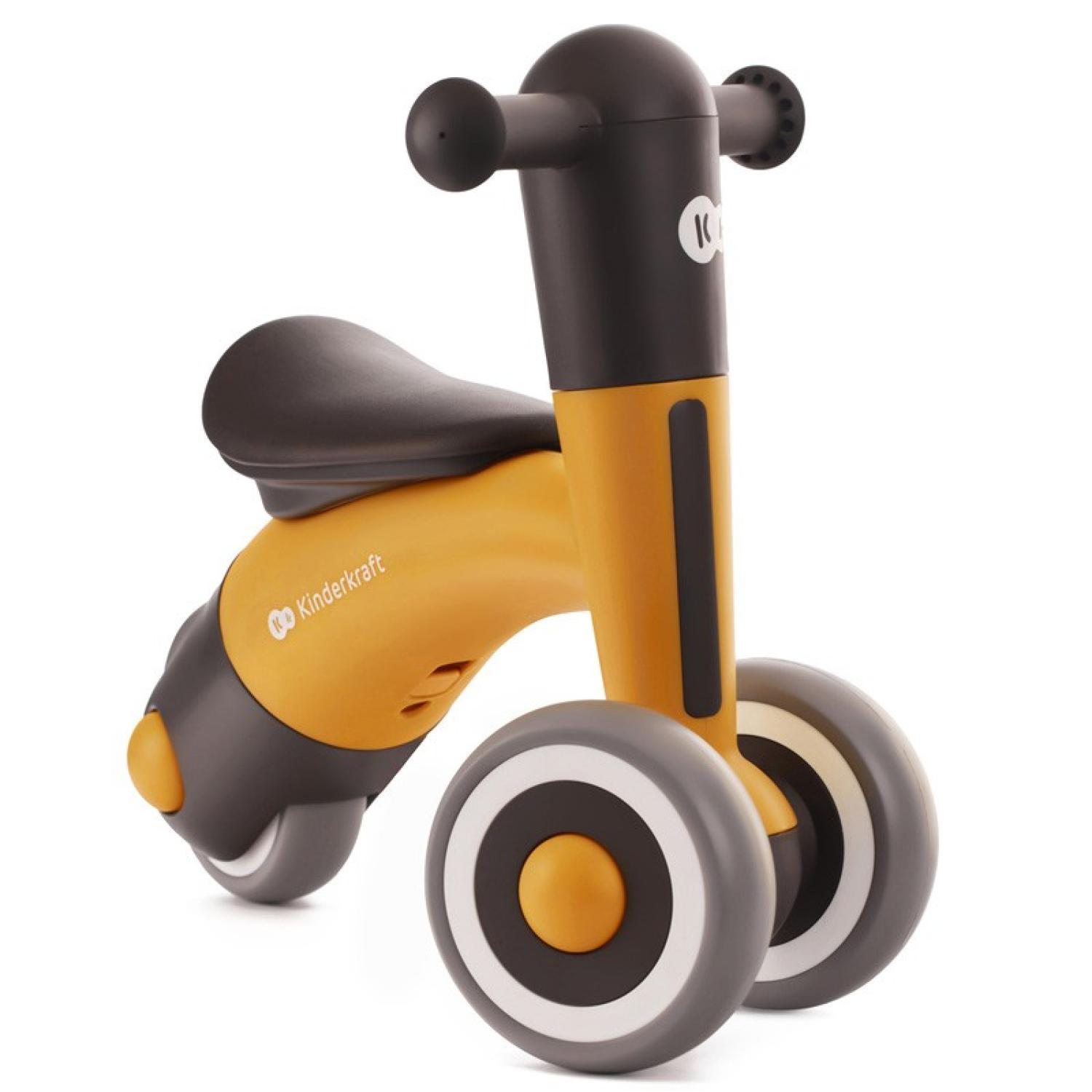 Una bici senza pedali Kinderkraft gialla e nera con ruote grigie e sella e manubrio neri. La bici è su sfondo bianco.