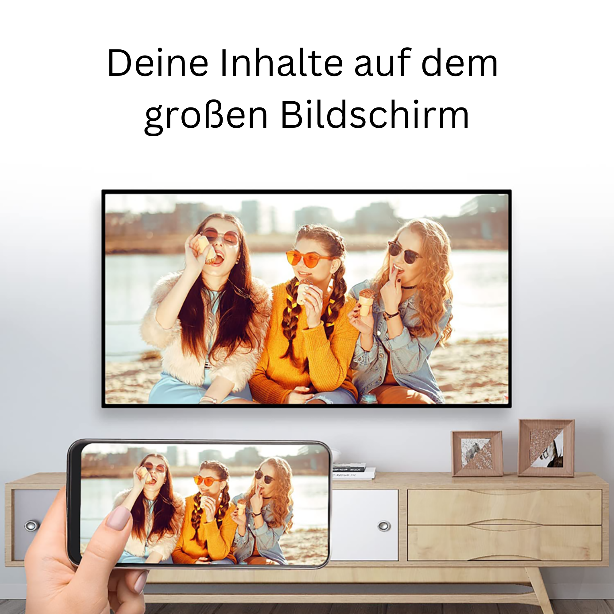 Drei Frauen mit Sonnenbrillen genießen Eis, das auf einem Fernseher angezeigt wird. Ein Telefon zeigt dasselbe Bild.