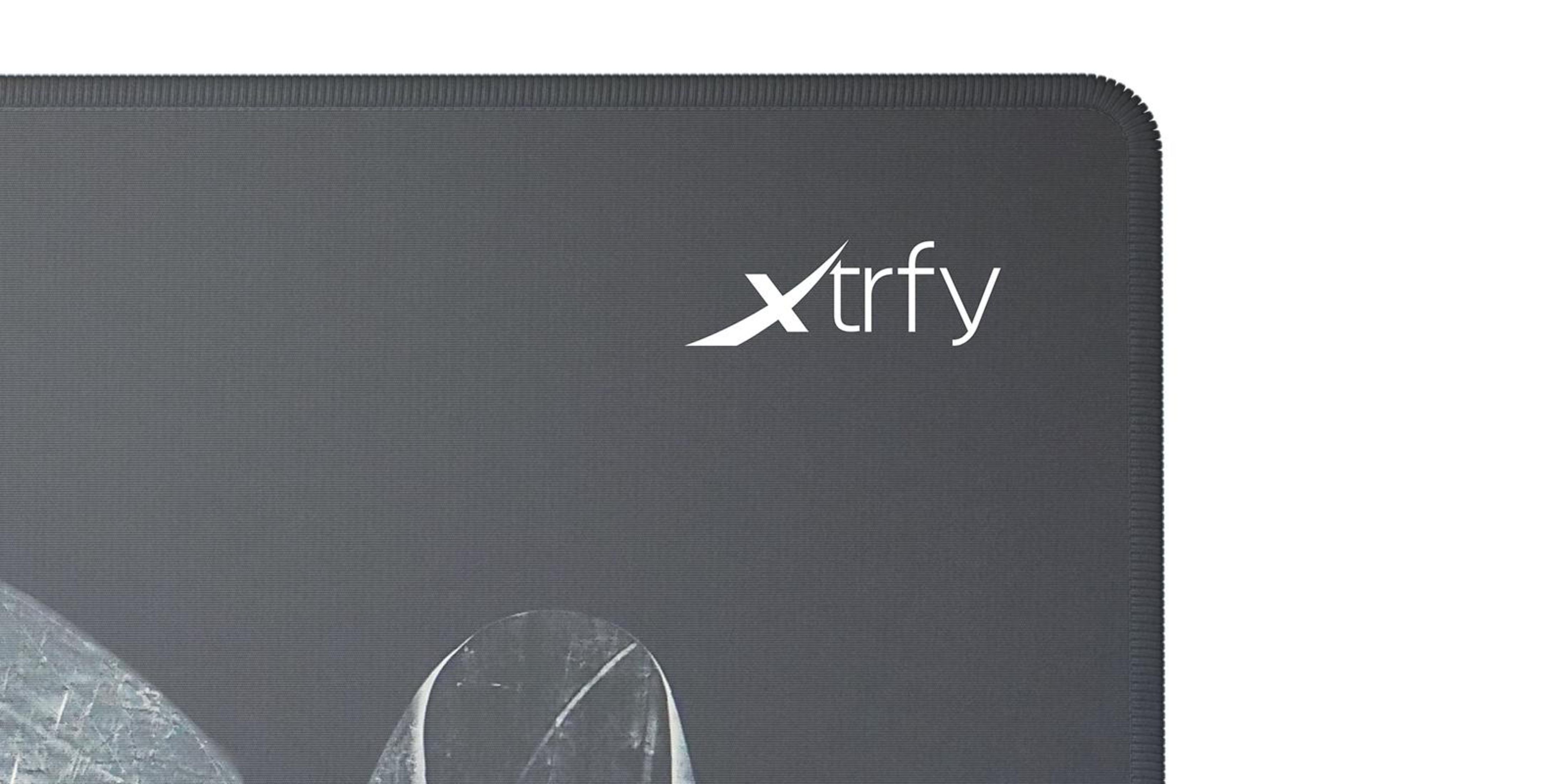 Primo piano di un tappetino per mouse Xtrfy grigio. Il logo bianco Xtrfy è in alto a destra. Il bordo è cucito. Sfondo bianco.
