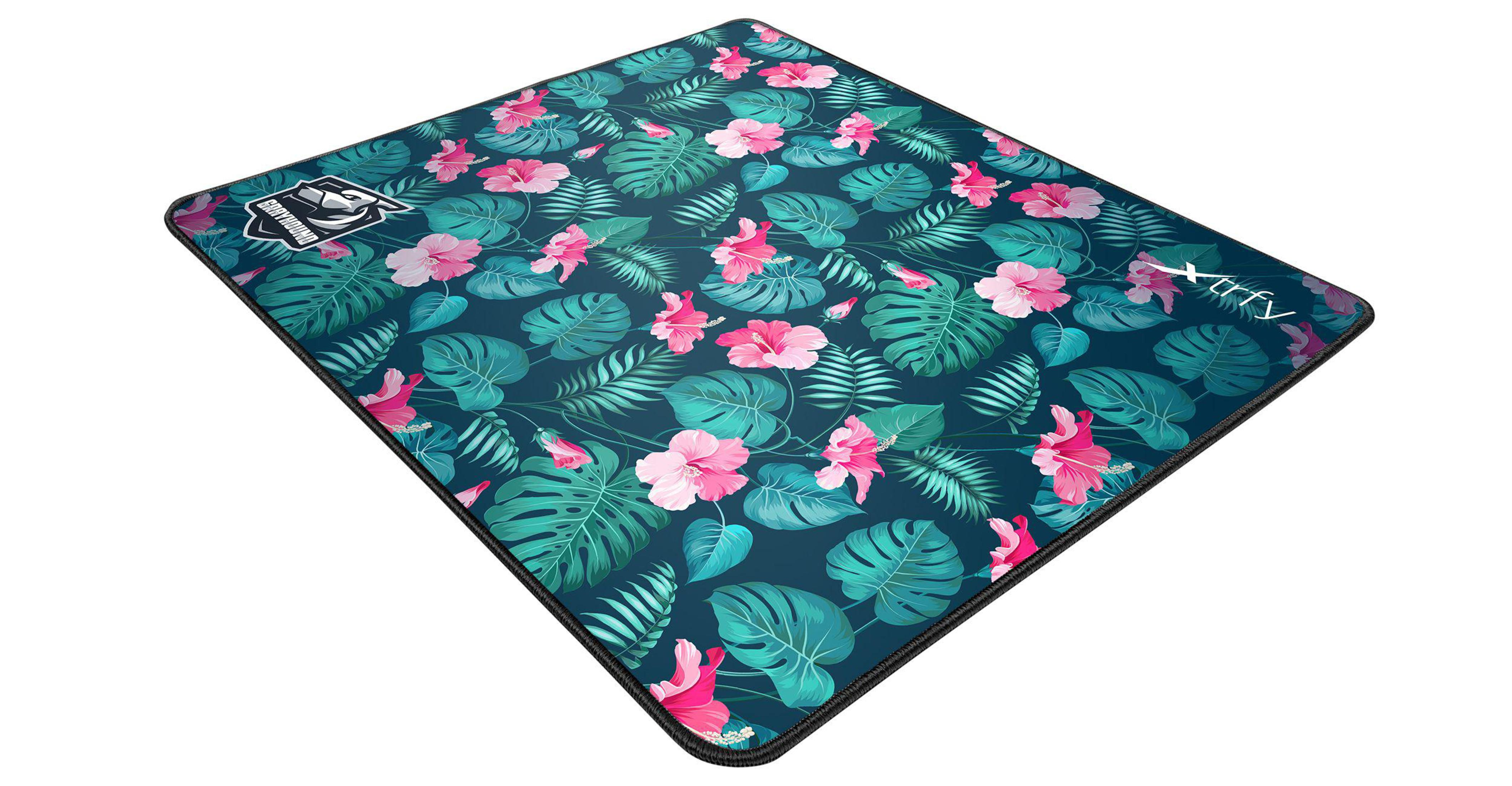 Un tapis de souris avec un motif floral d'hibiscus roses et de feuilles vertes sur fond bleu foncé. Les bords sont noirs.